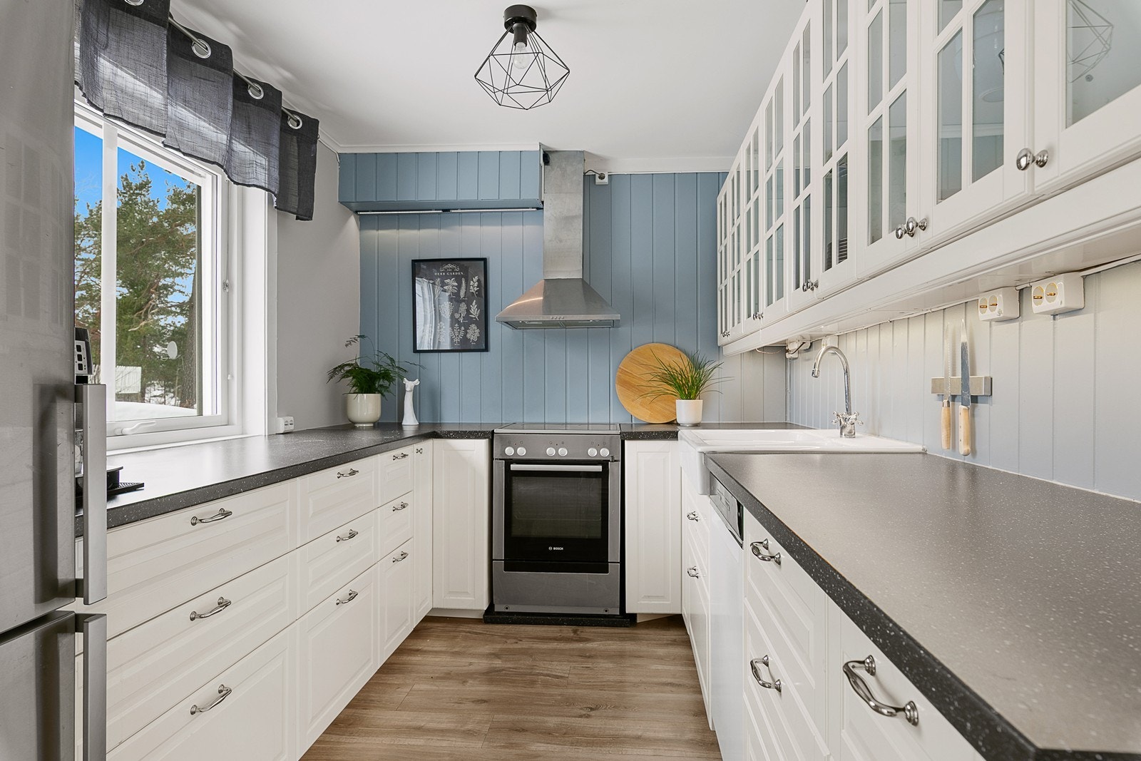 Kjøkkenet har en lekker innredning med hvite profilerte fronter, laminert benkeplate og frittstående hvitevarer som medfølger leiligheten. Galleribilde