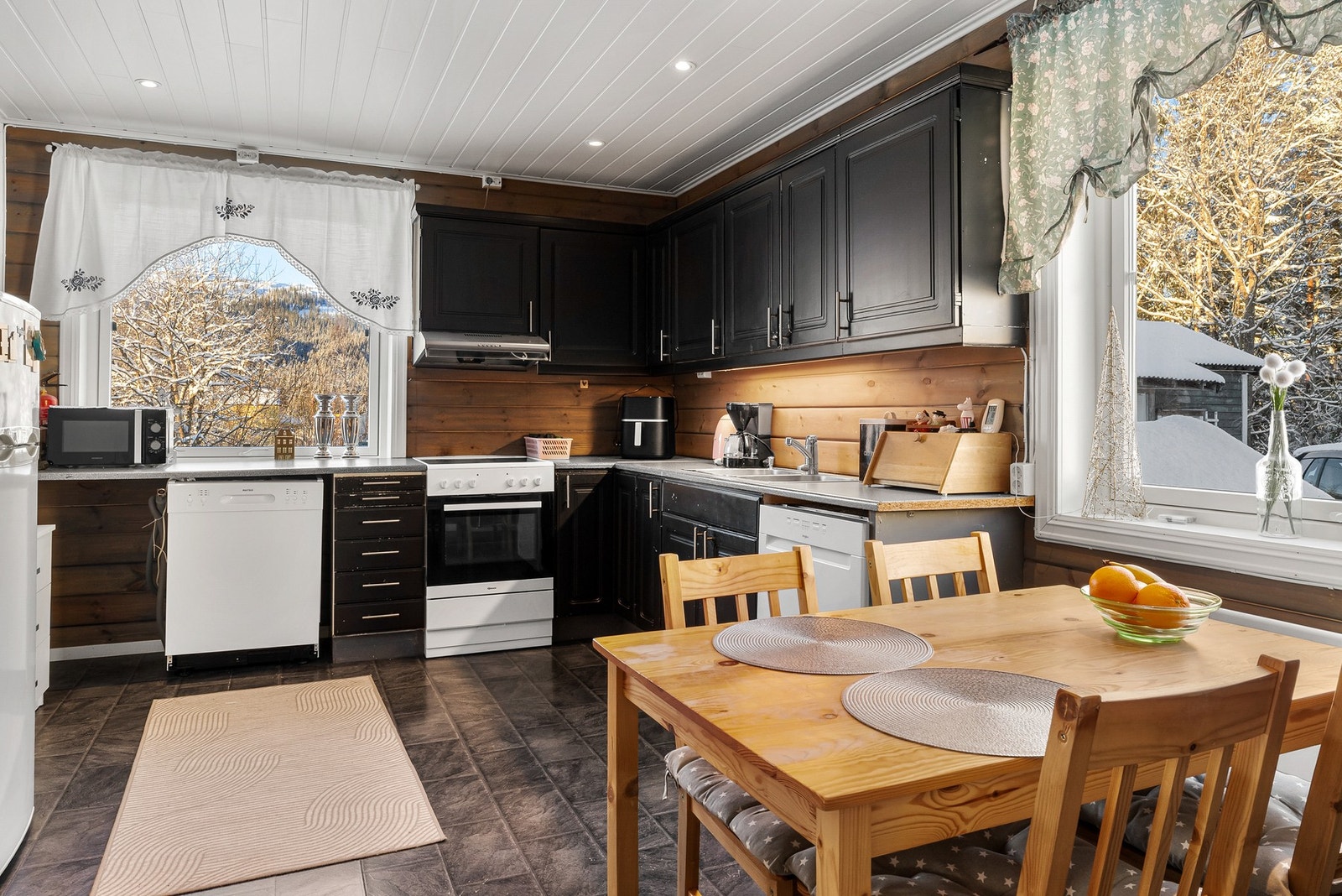 Romslig kjøkken med malte profilerte fronter og benkeplate av laminat med nedfelt servant Galleribilde