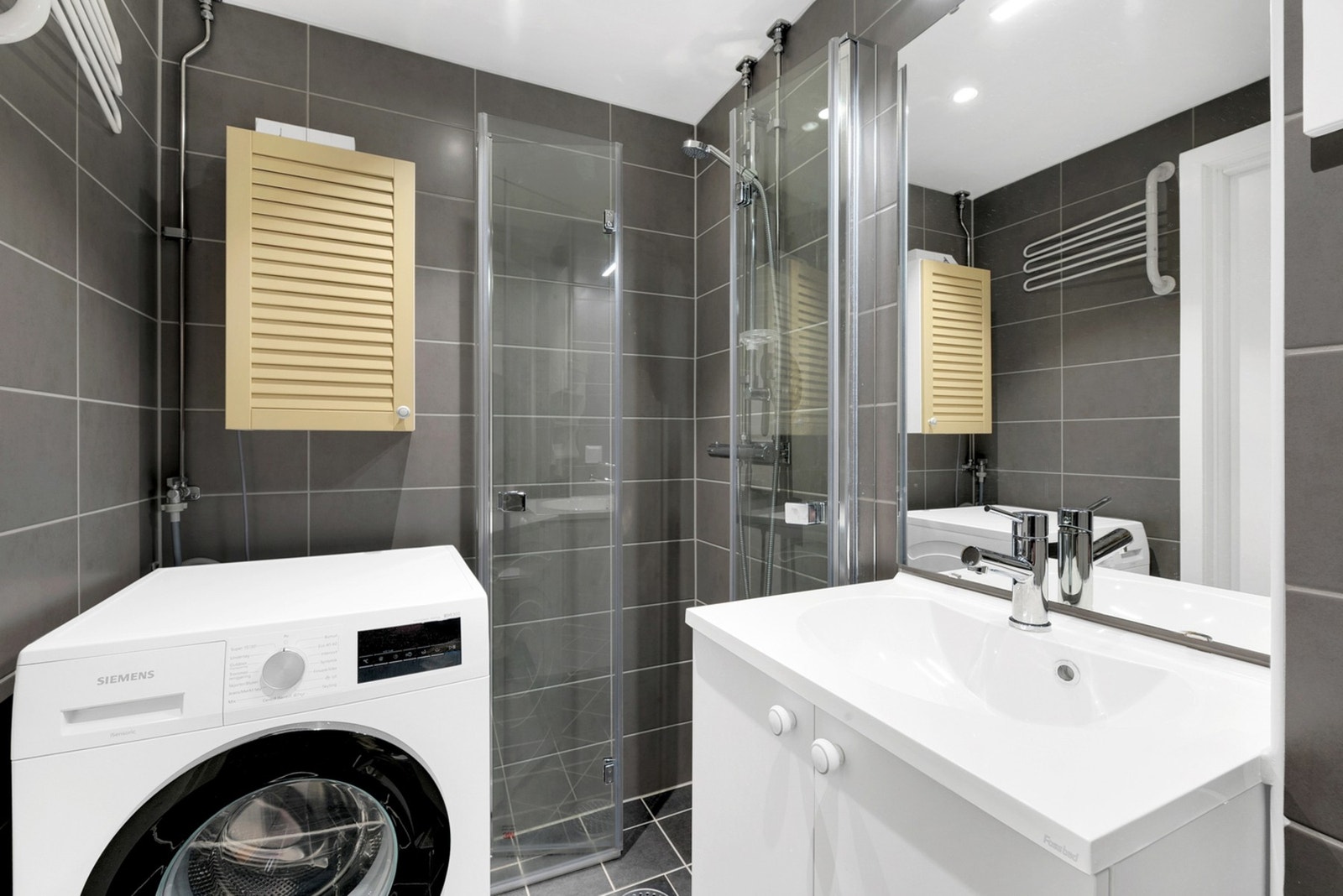 Lekkert baderom som ble totalrenovert i regi av borettslaget i 2025, med varmekabler og opplegg for vaskemaskin. Galleribilde