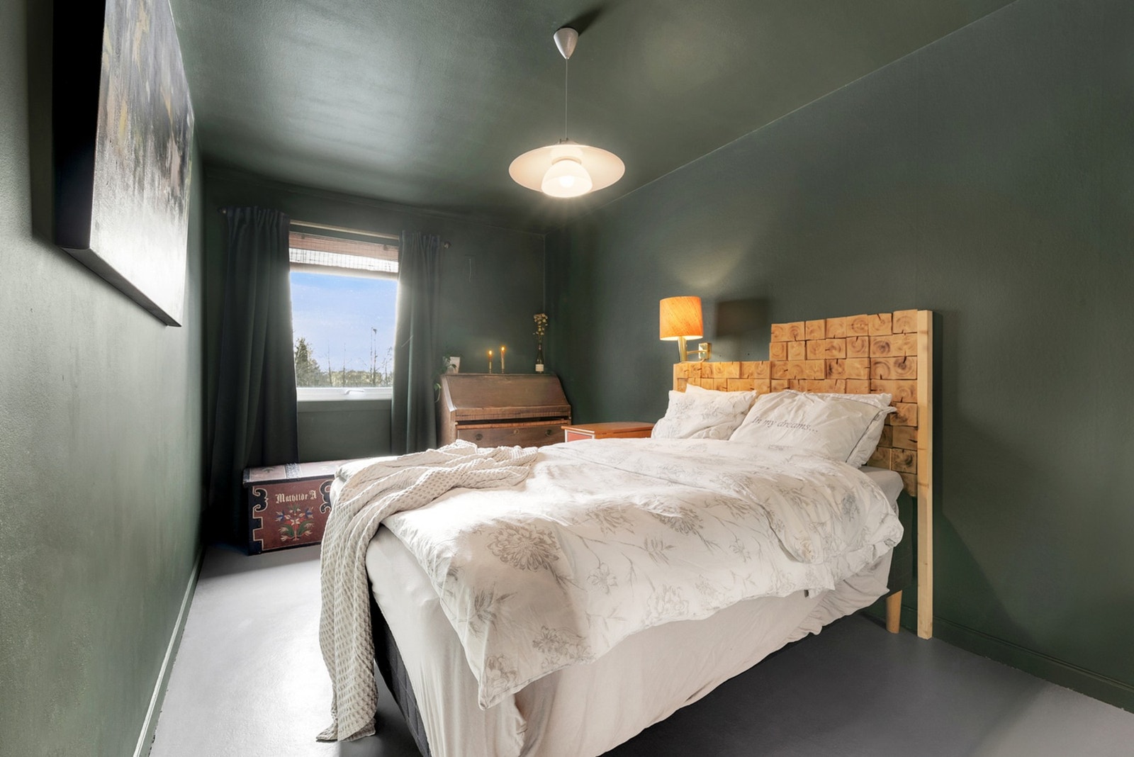 Soverommet er lunt og innbydende, malt i en behagelig mørkere fargetone som skaper en rolig atmosfære. Galleribilde