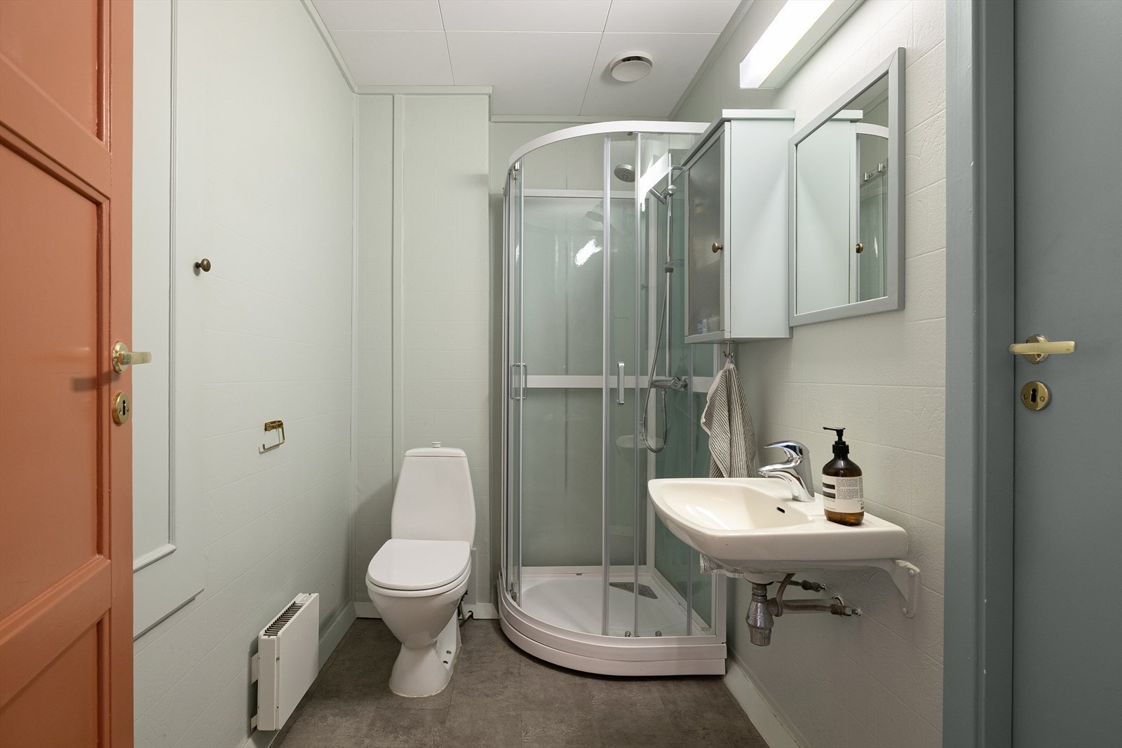 Romslig bad med dusjkabinett fra 2022, toalett, servant, vegghengt skap og speil. Borettslaget har fellesvaskeri i kjeller for vask av tøy. Galleribilde