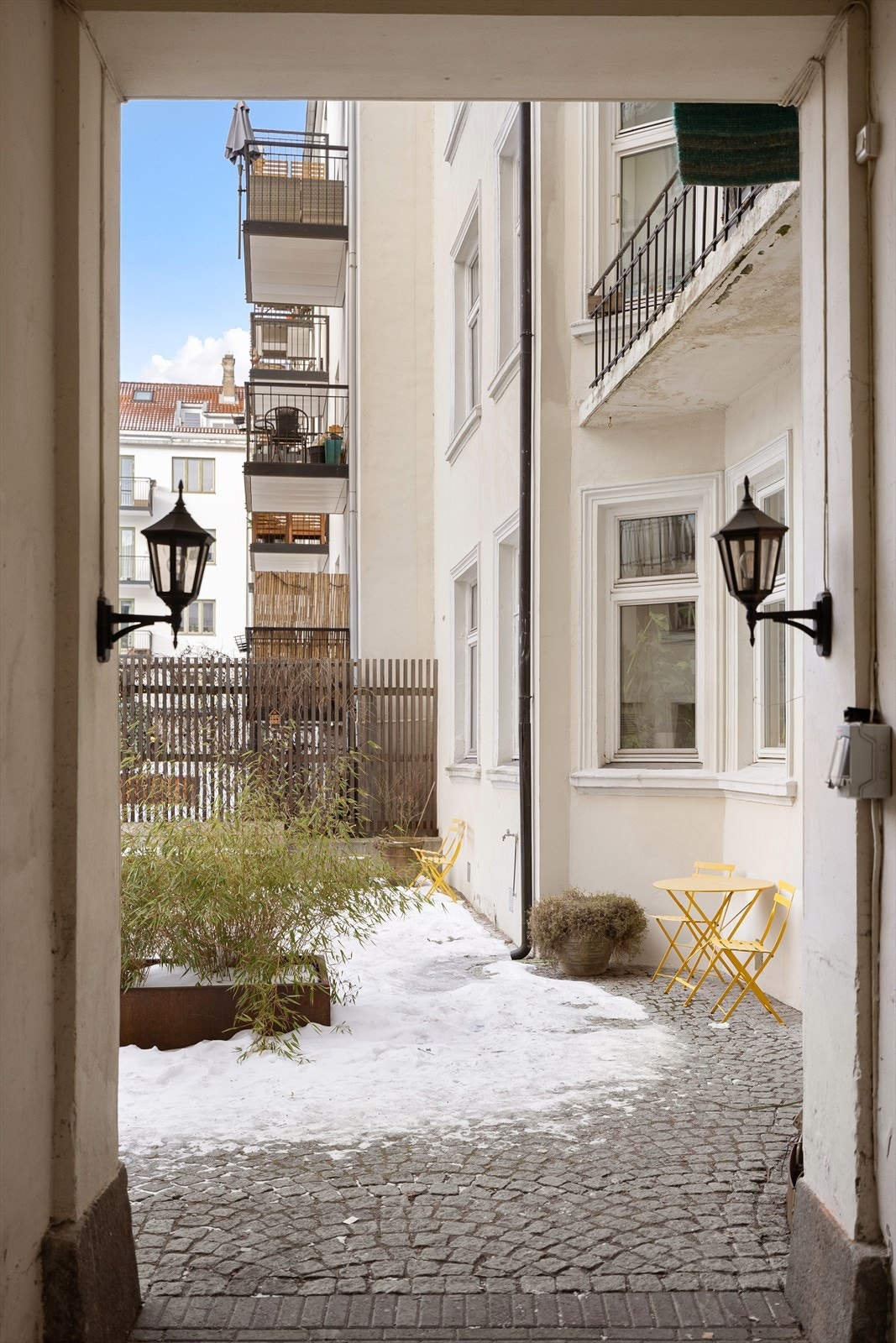 Inngangspartiet fra bakgården er innbydende med brostein og klassiske utelamper. Galleribilde