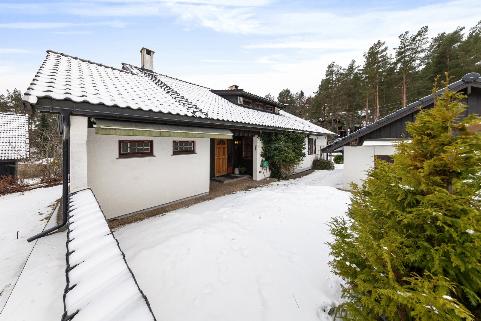 Uteområde ved inngangen er belagt med heller. Her er det også en utepeis. Galleribilde