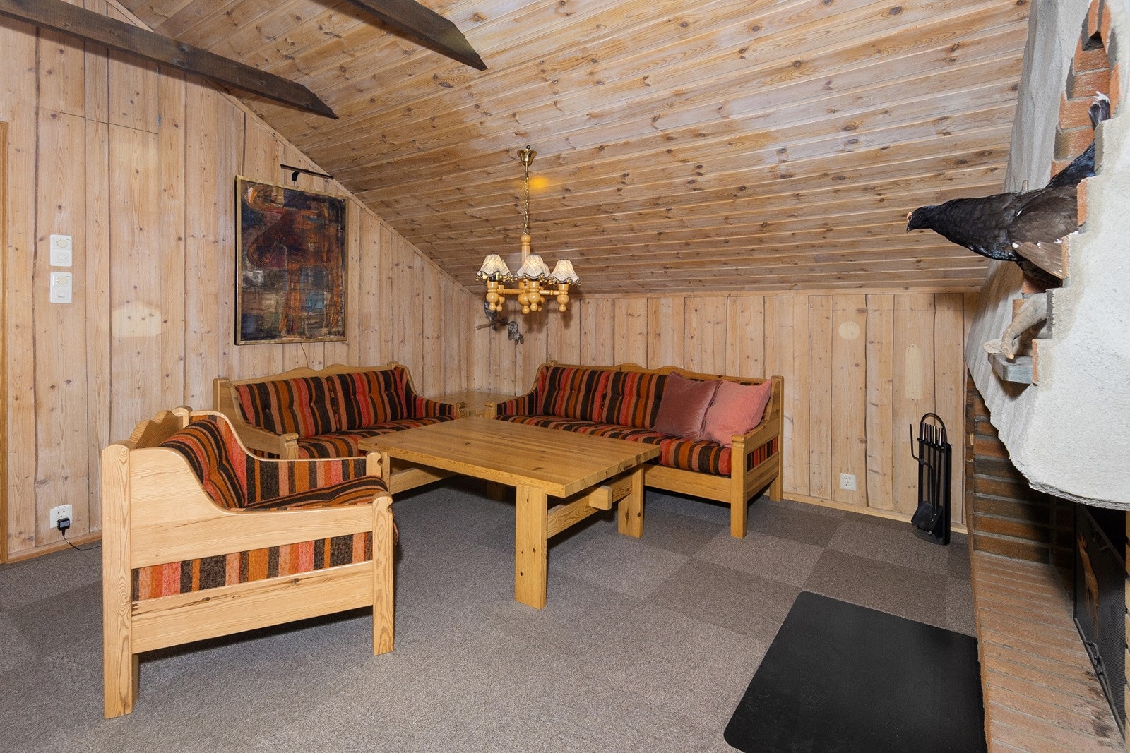 God plass til sofa og bord forran peisen i loftstuen. Galleribilde