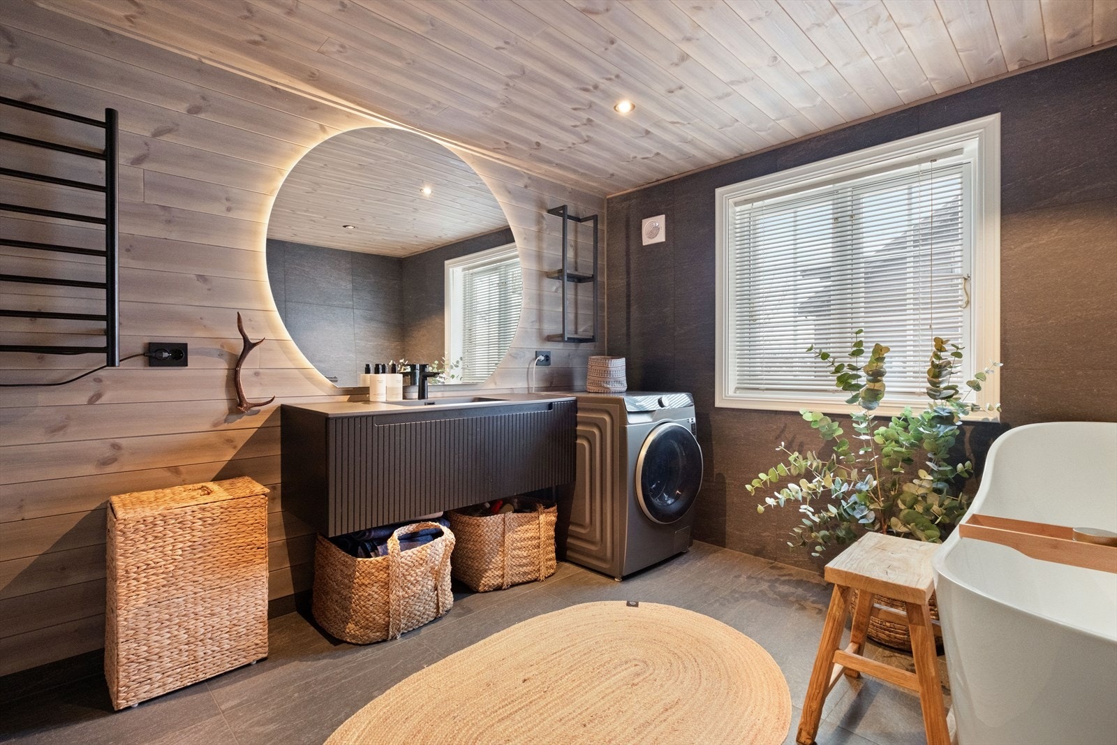 Badet har en helstøpt servant med mørk profilert innredning. Galleribilde