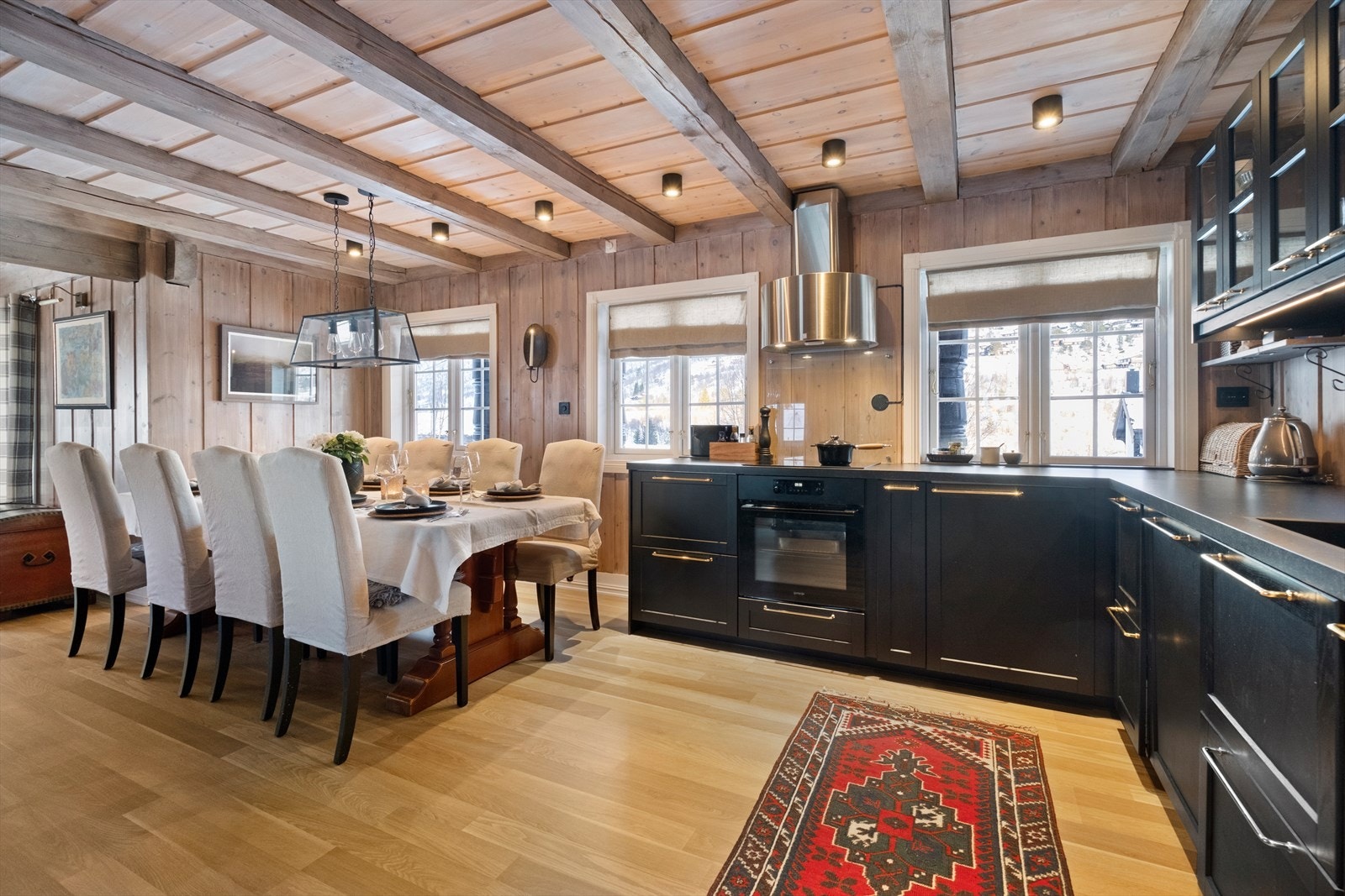 Kjøkkenet har mørke profilerte fronter og integrerte hvitevarer for en stilren arbeidsflate. Galleribilde