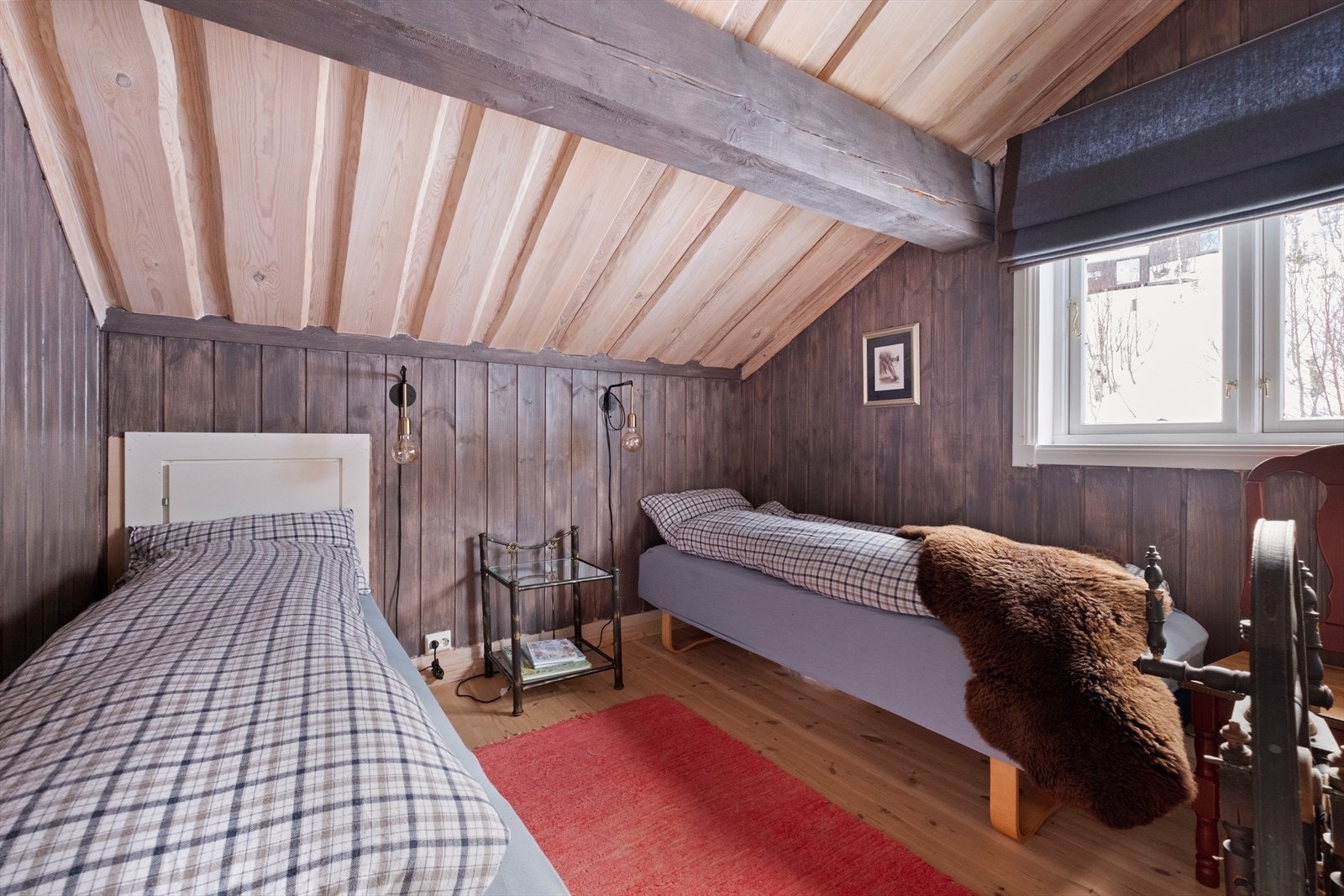 To enkeltsenger plassert under skråtak med trepanel. Galleribilde