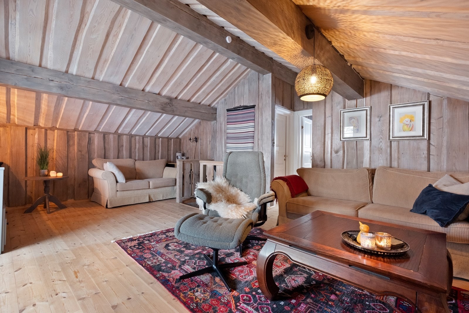 Skråtaket i loftstuen skaper en koselig atmosfære, med plass til flere sittegrupper. Galleribilde