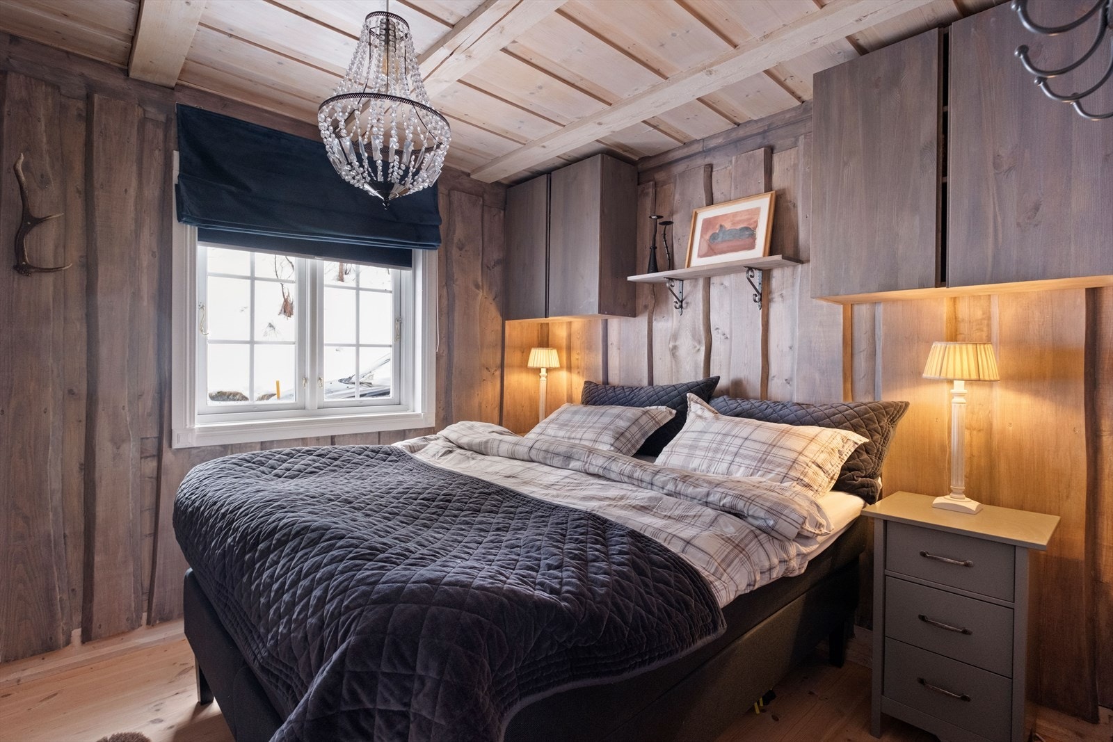 Vegger i trepanel gir et rustikt preg til rommet. Rommet har også vegghente skap. Galleribilde