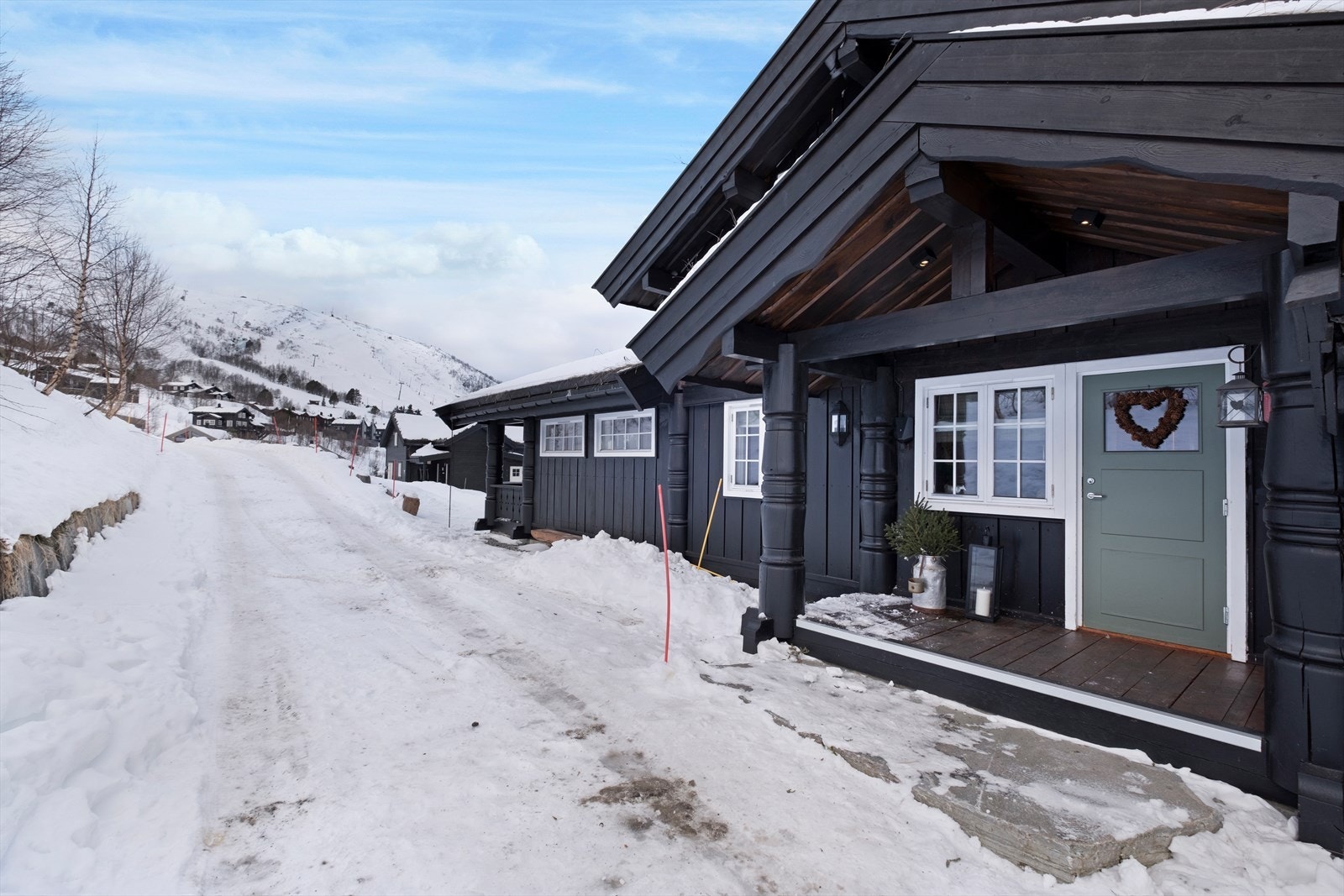 Den malte boddøren er fra byggeåret og gir enkel tilgang til oppbevaringsrom. Galleribilde