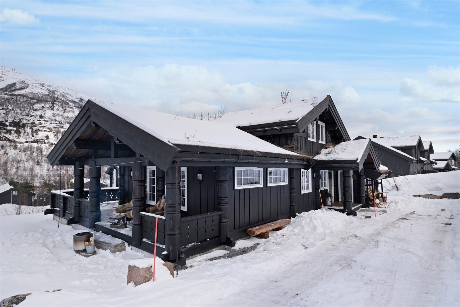 Hytta har en malt hovedytterdør med vindusfelt, som gir et innbydende inngangsparti. Galleribilde