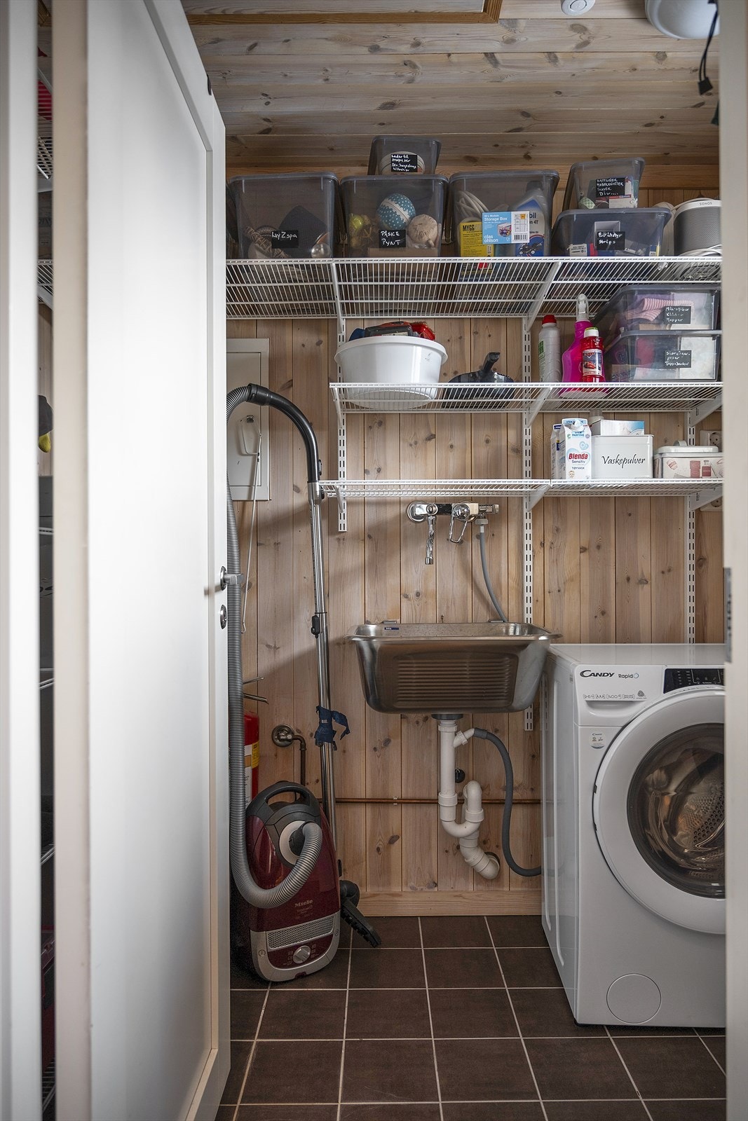 Vaskerom/teknisk rom/bod med opplegg for vaskemaskin, utslagsvask og øvrig oppbevaringsplass i hyller Galleribilde