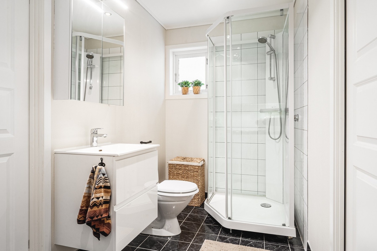 Badet på 5,8 kvm har flislagt gulv og slette malte vegger. Badet er innredet med dusjkabinett, toalett og baderomsinnredning. Galleribilde