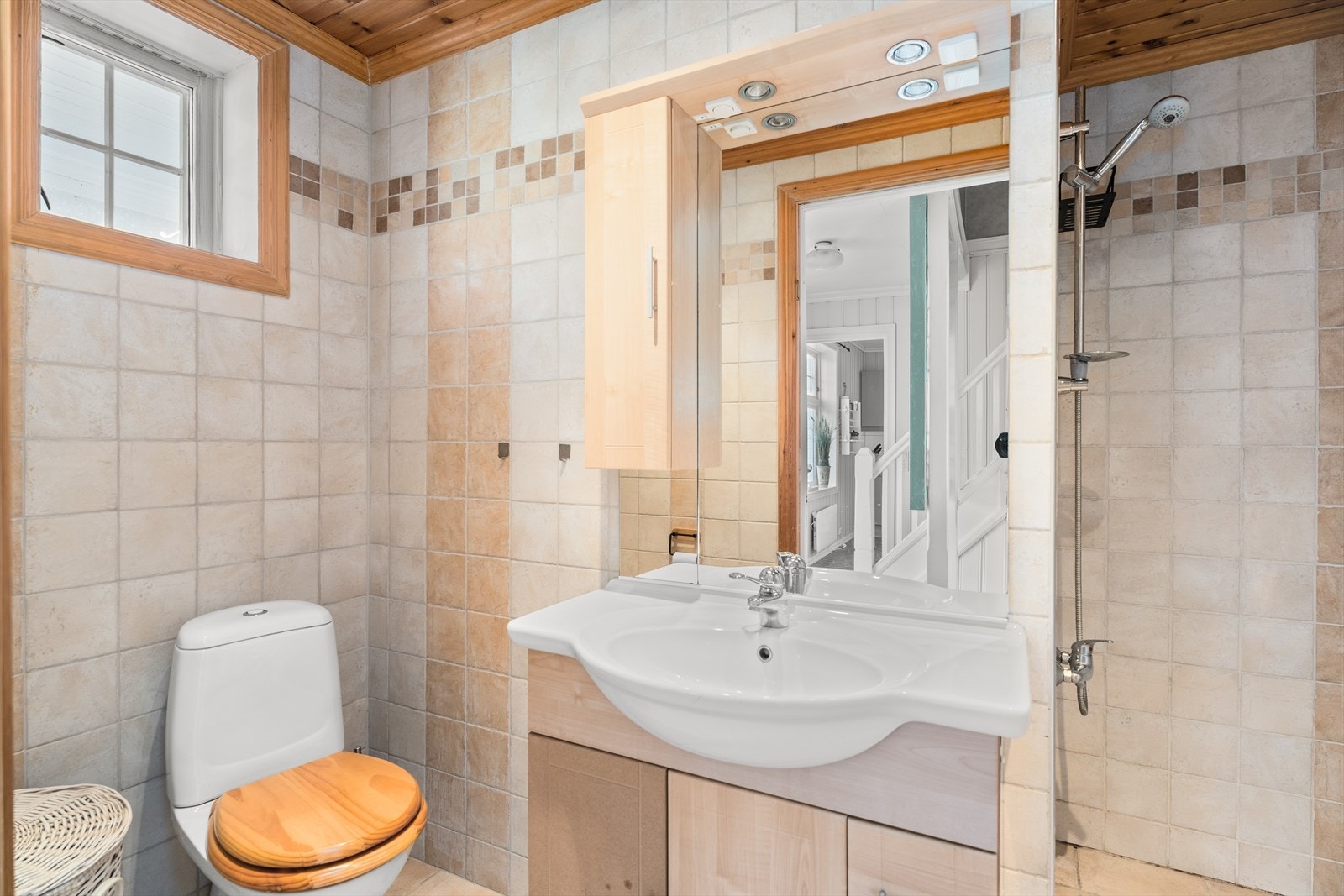 Lyst bad med moderne fliser, praktisk dusjhjørne og toalett. Galleribilde