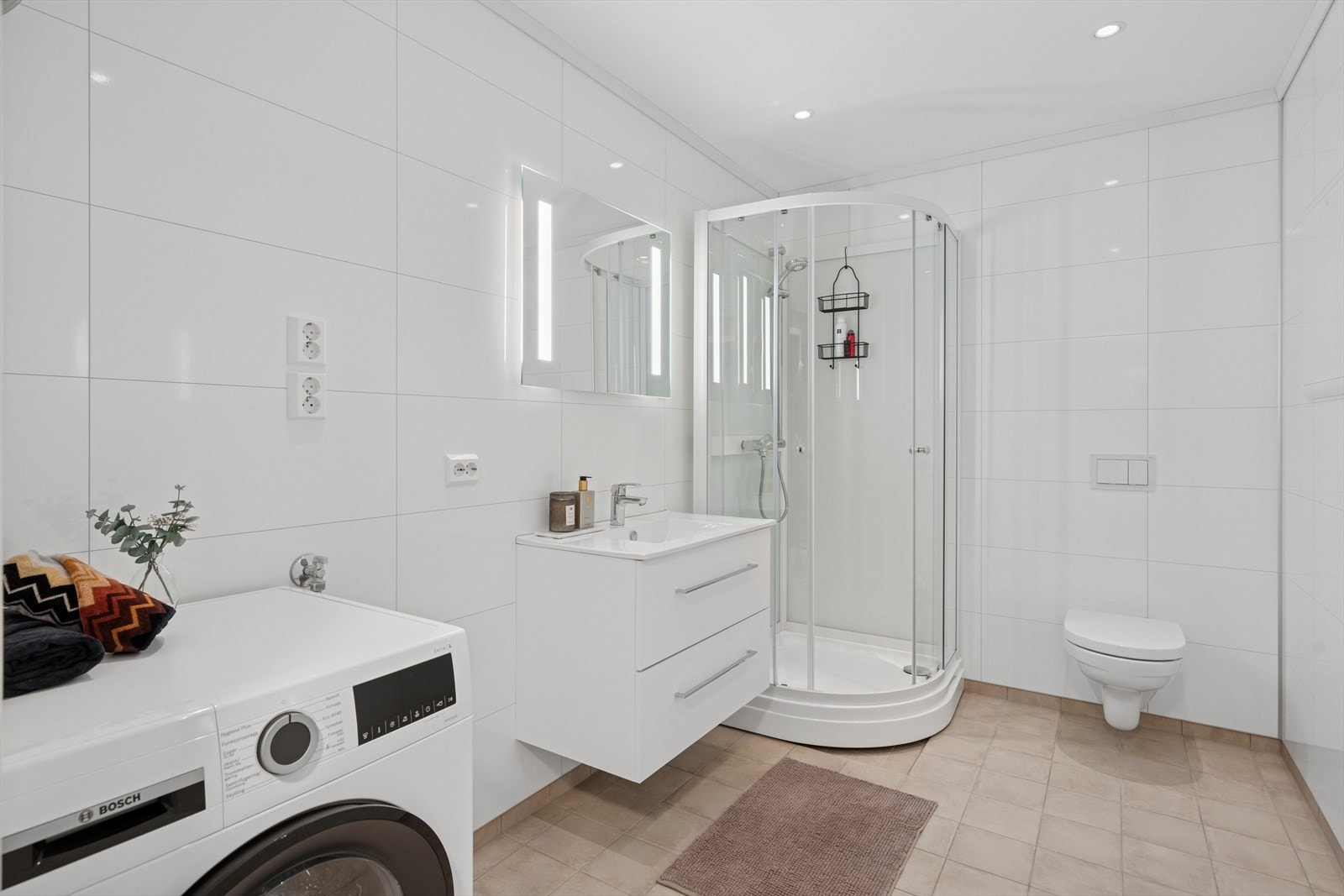 Leiligheten byr på et flott og romslig baderom. Rommet er gjennomført med pene fliser i moderne fargetoner på gulv og pene baderomsplater på vegger. Galleribilde