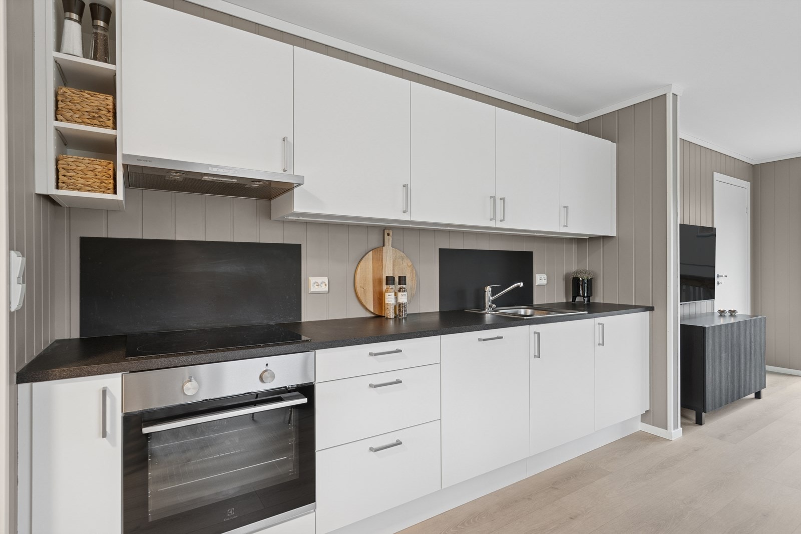 Det flotte kjøkkenet har montert en moderne kjøkkeninnredning med flere flotte detaljer som godt med overskap og integrerte hvitevarer som platetopp, oppvaskmaskin og stekeovn. Galleribilde