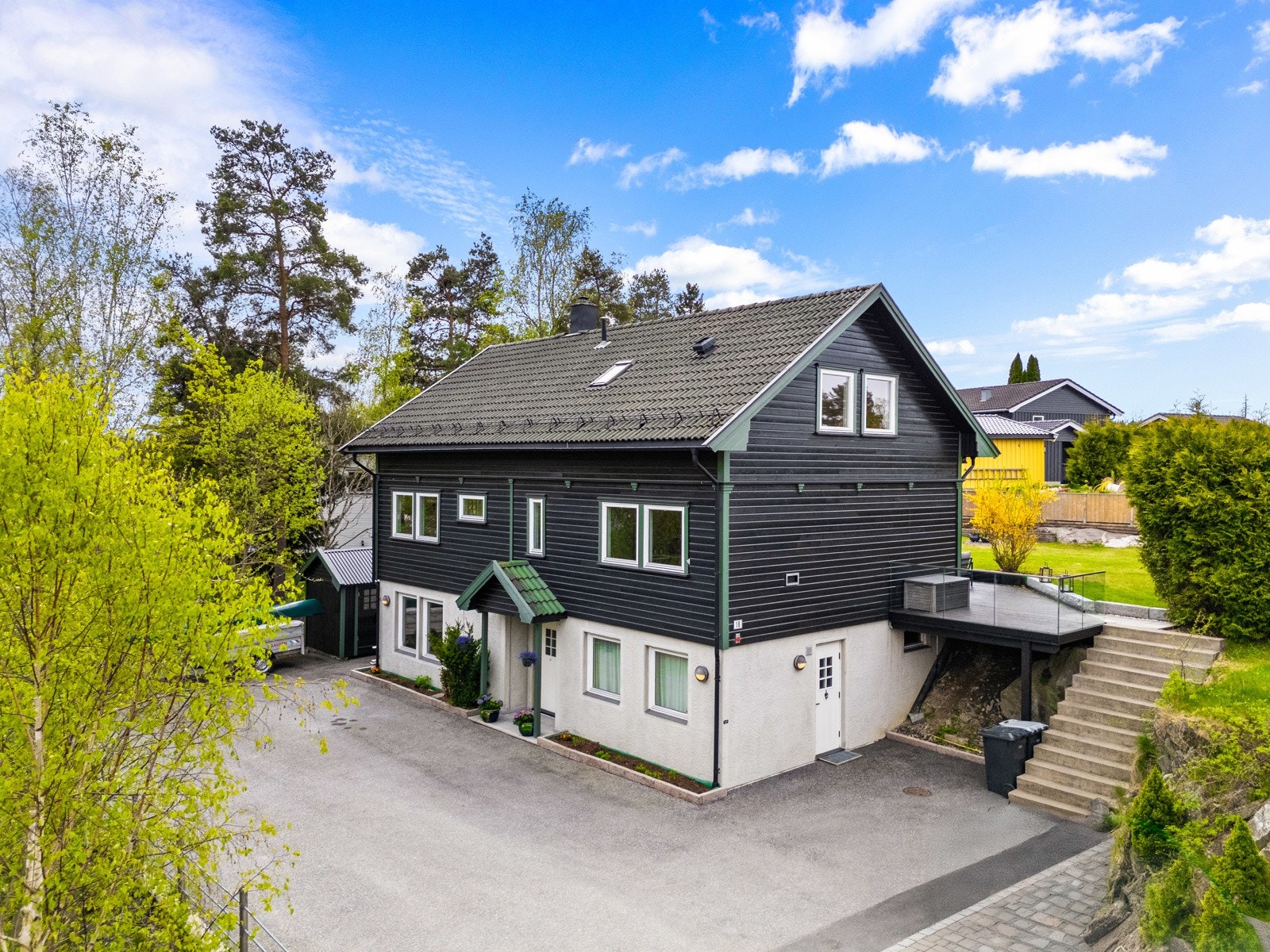 Tomten er pent opparbeidet med en stor, asfaltert gårdsplass mot nordøst, med trapp opp til hagen i sydvest. Galleribilde