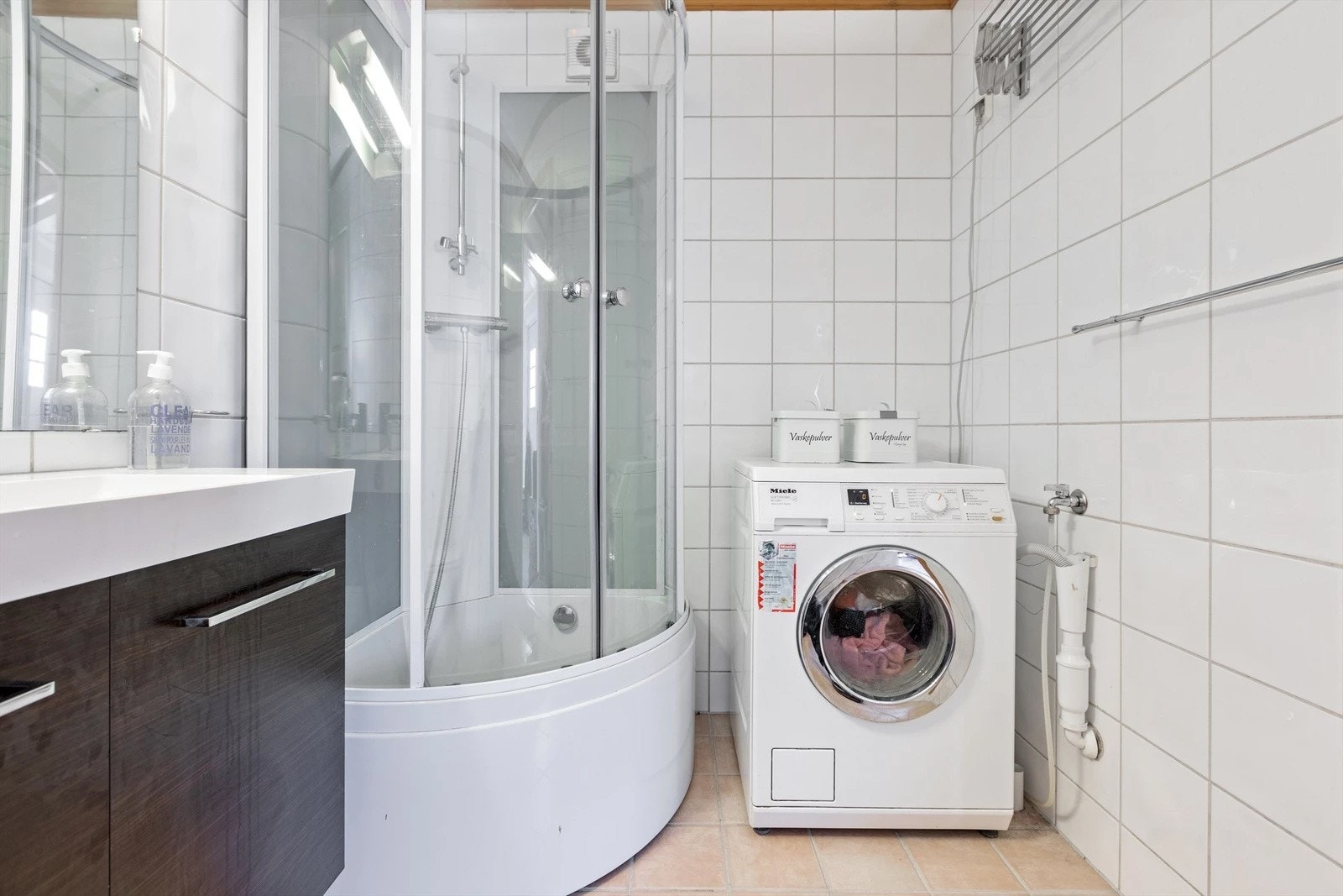 Badet i hybelen er helfliset med pen innredning, dusjkabinett, toalett og opplegg for vaskemaskin. Galleribilde