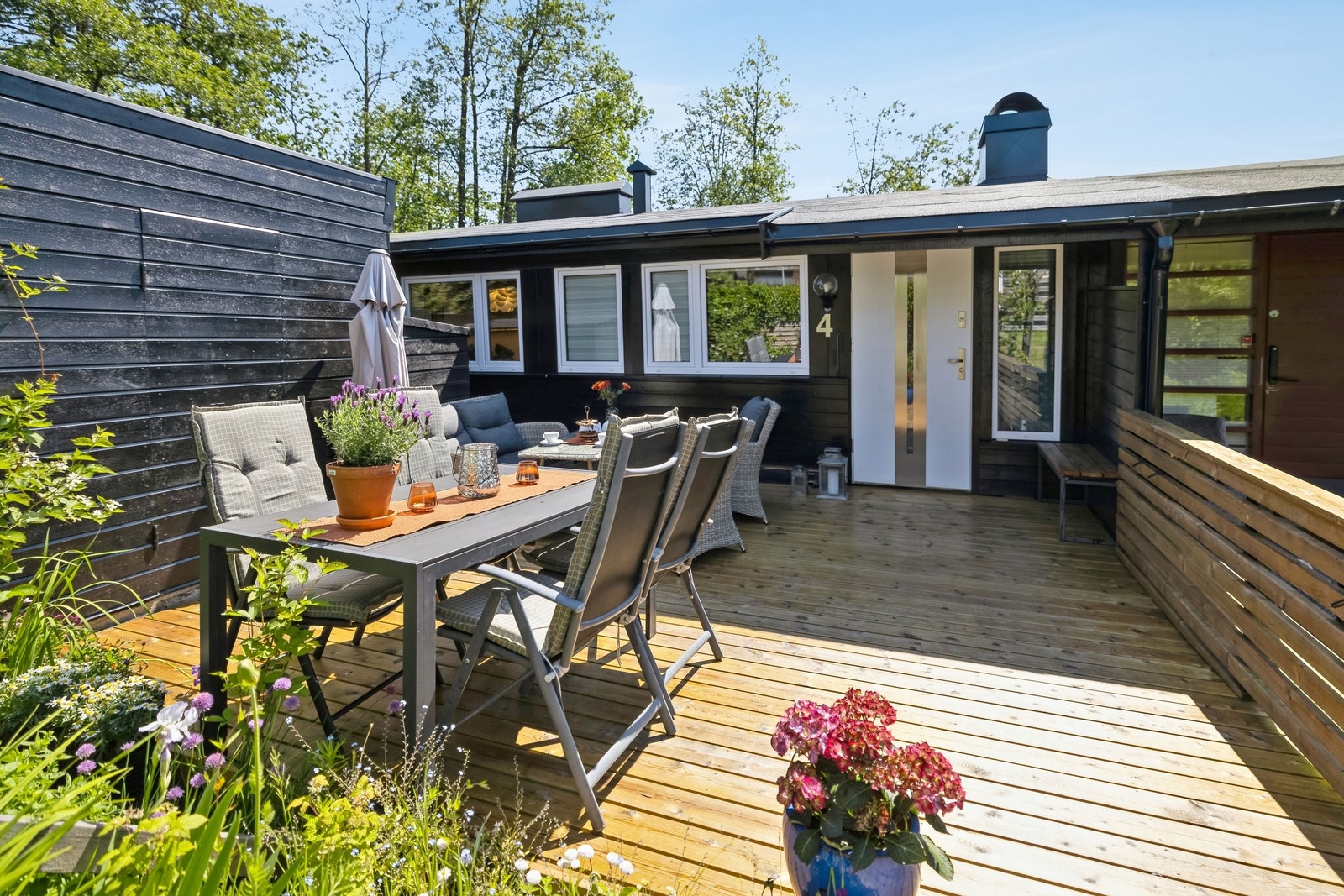 Skjermet inngangsparti med hyggelig uteområde med platting. Utvendig bod er også synlig til venstre, samt vedskur Galleribilde