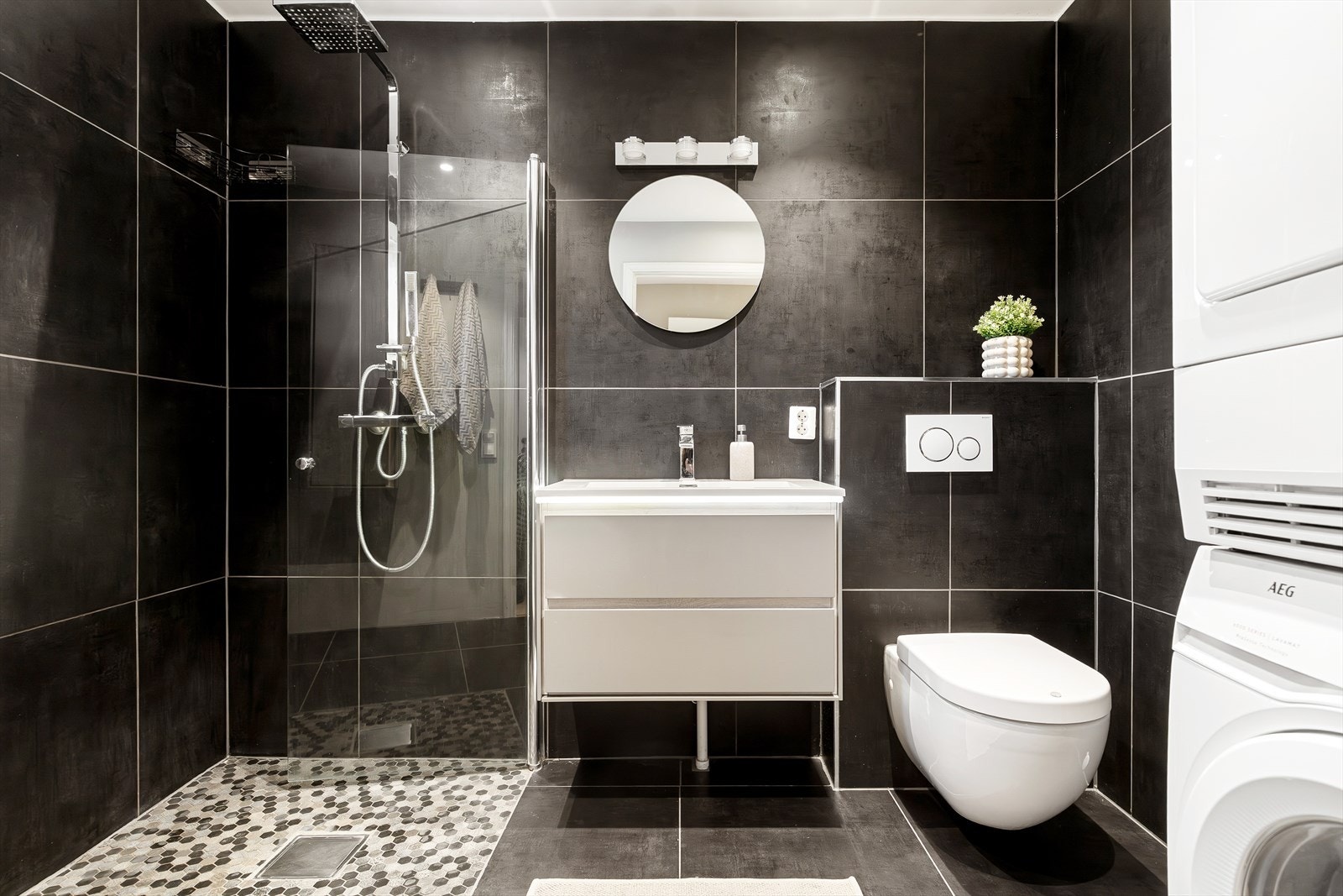 Pent og funksjonelt bad fra 2018 med gulvvarme. Badet er innredet med servant med underskap, speil og vegghengt WC, samt dusjnisje med vegghengte glassdører. Galleribilde