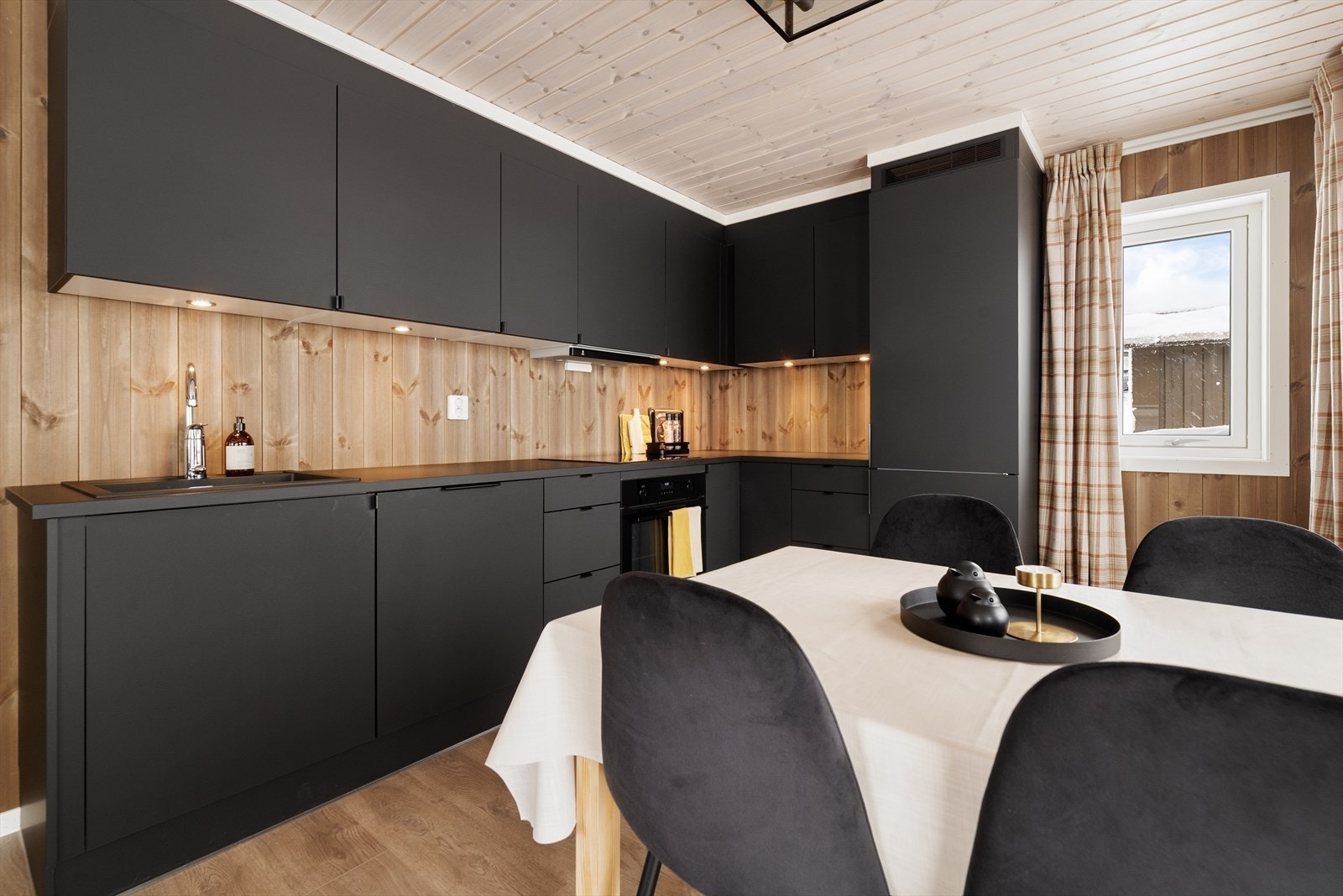 Kjøkkenet har god belysning over benken, og det er installert vannstoppsystem. Over kokesonen er det ventilator fra Røros Hetta, med kullfilter. Galleribilde