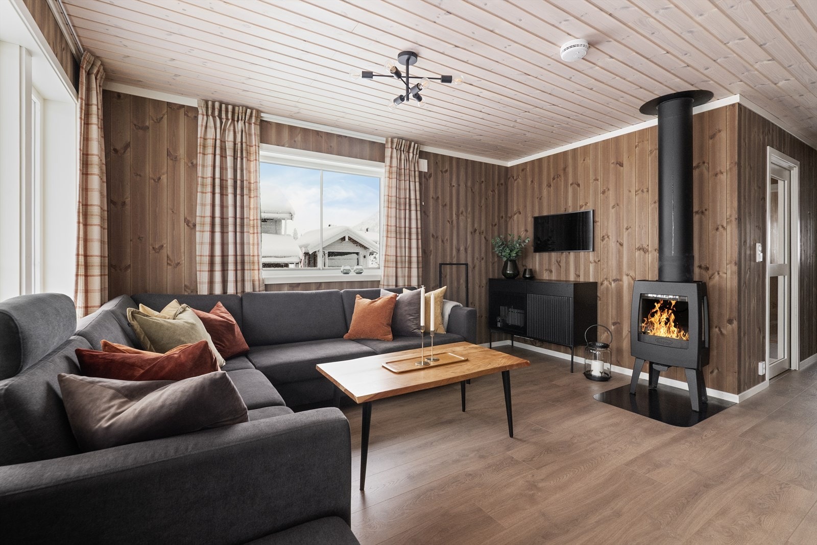 Stua har en moderne vedovn med glassfelt på flere sider slik at peiskosen kan nytes maksimalt. Galleribilde