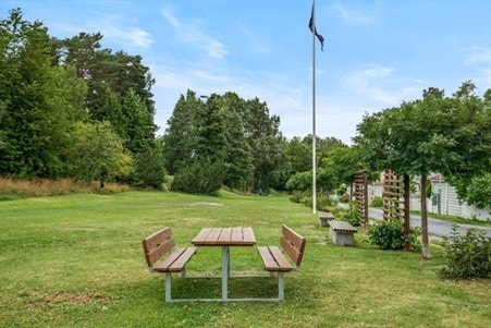 Pent opparbeidet felles tomt for borettslaget med asfalterte gang/stikkveier, lekeplasser, sittegrupper, grøntarealer, trær og beplantning. Galleribilde