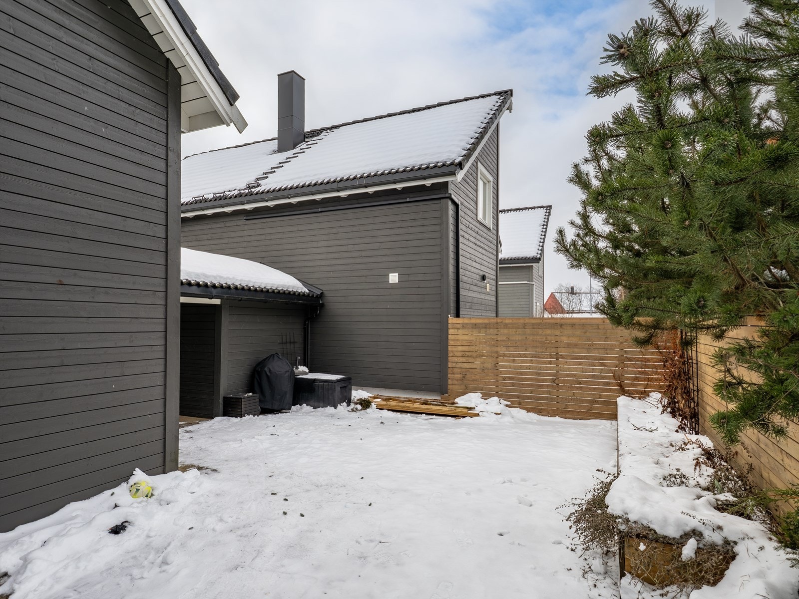 Her er det laget vedskjul, sittebenk med plantekasse og en liten thujahekk. Galleribilde