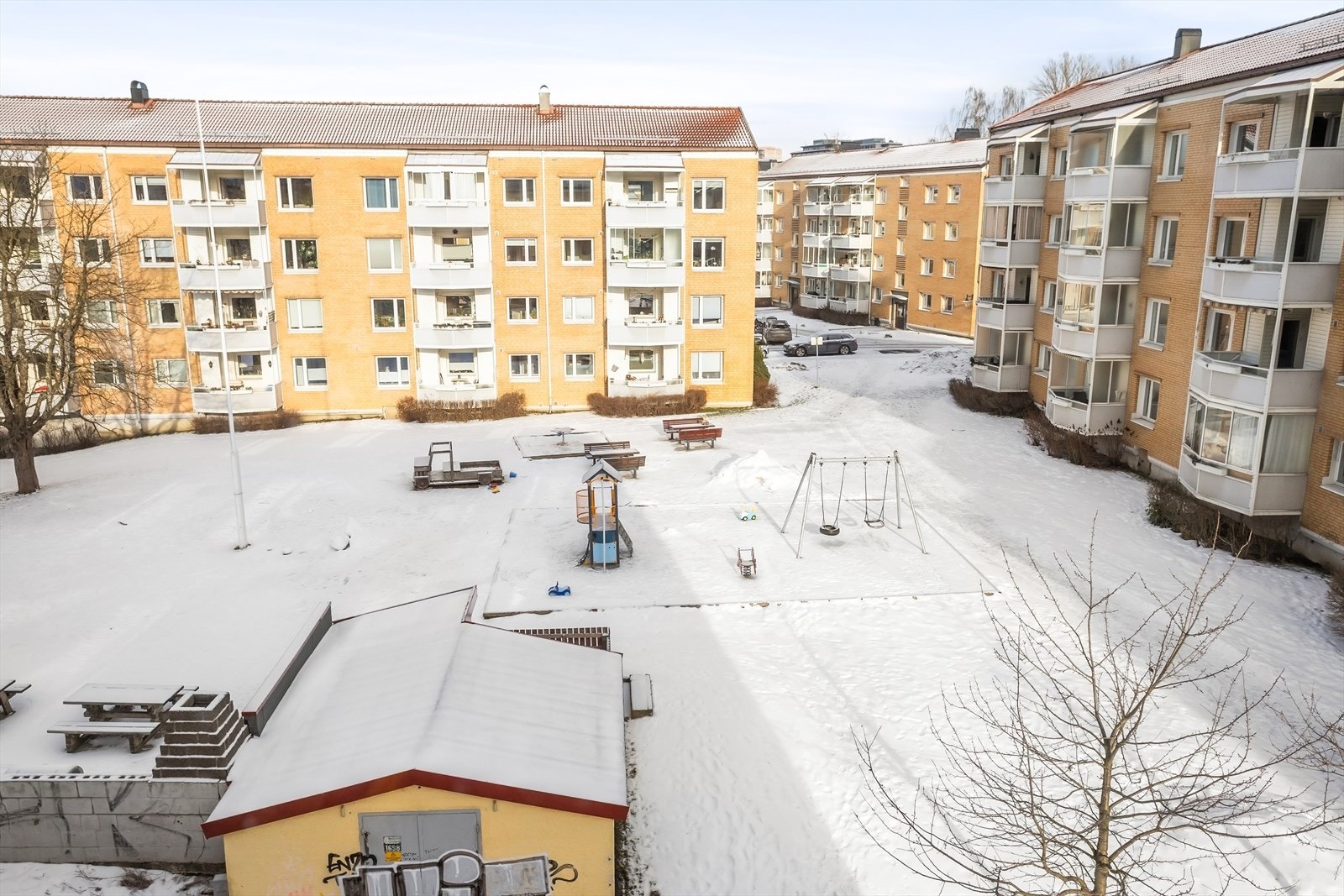 Åpen plass mellom byggene gir en luftig følelse og godt med naturlig lys inn i boligen. Her har du oversikt over lekeplass, sittebenker og gode oppholdsarealer - Perfekt for både barnefamilier! Galleribilde