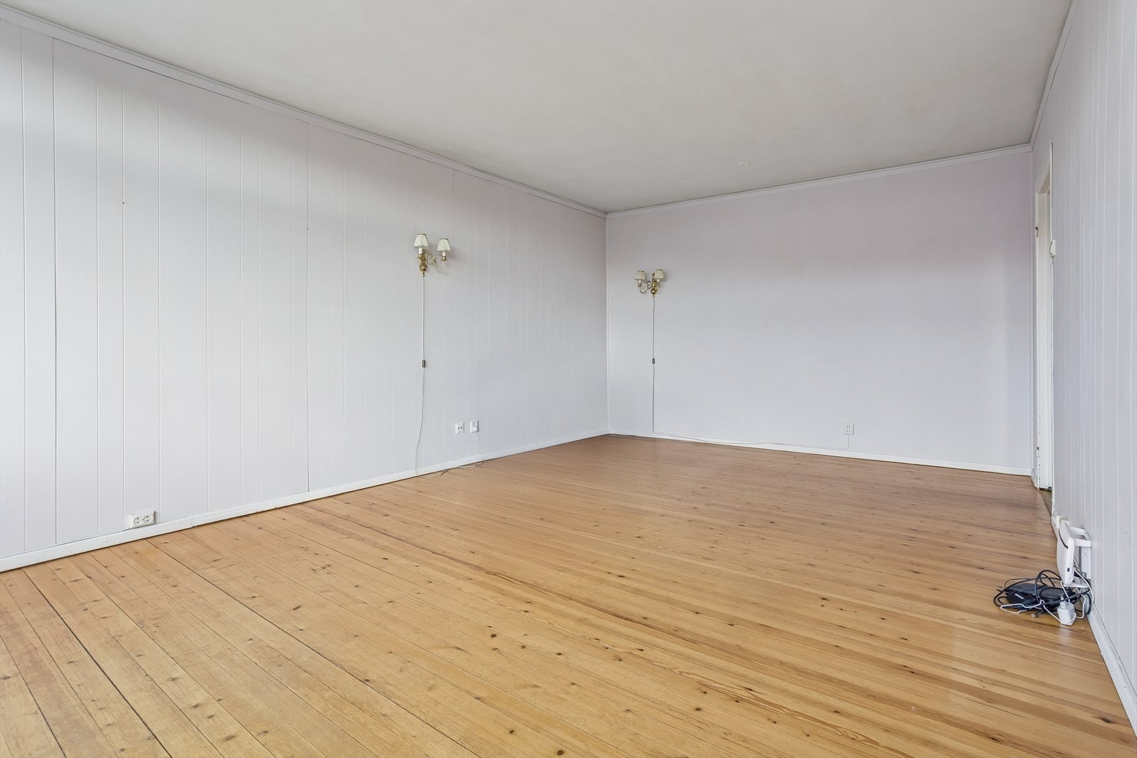 Stuen på 23 kvm har originale tregulv og god plass til både sofagruppe og spisebord. Galleribilde