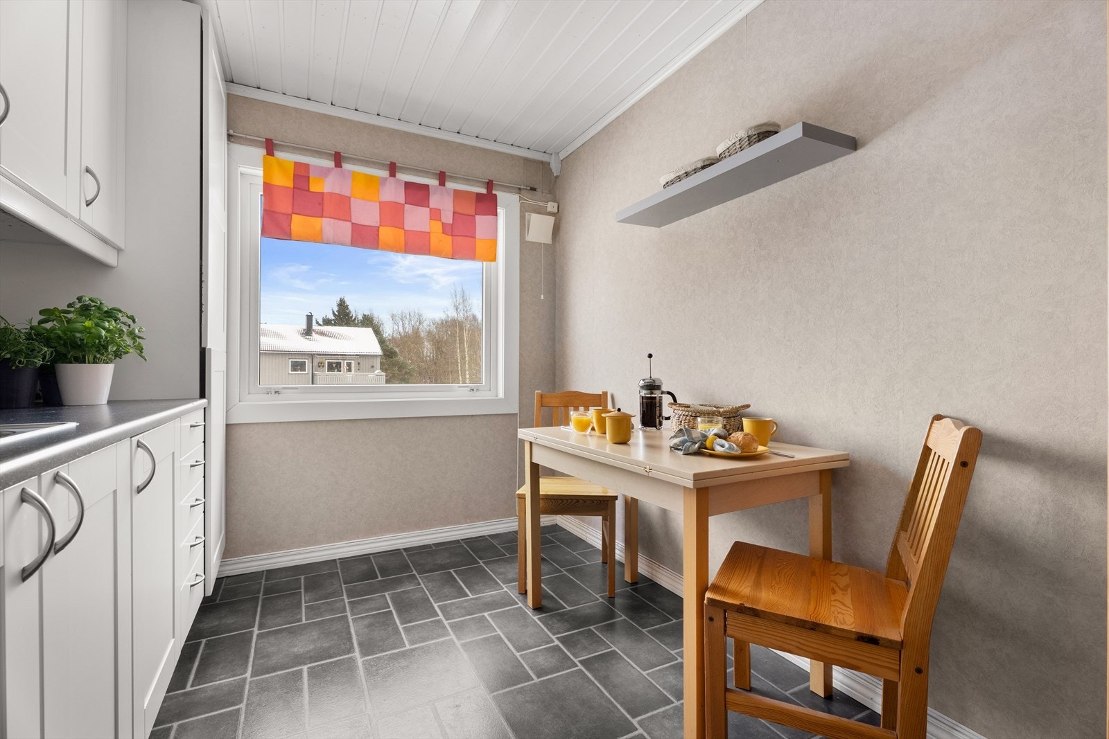 Kjøkkenet har en hyggelig spiseplass ved vinduet. Galleribilde