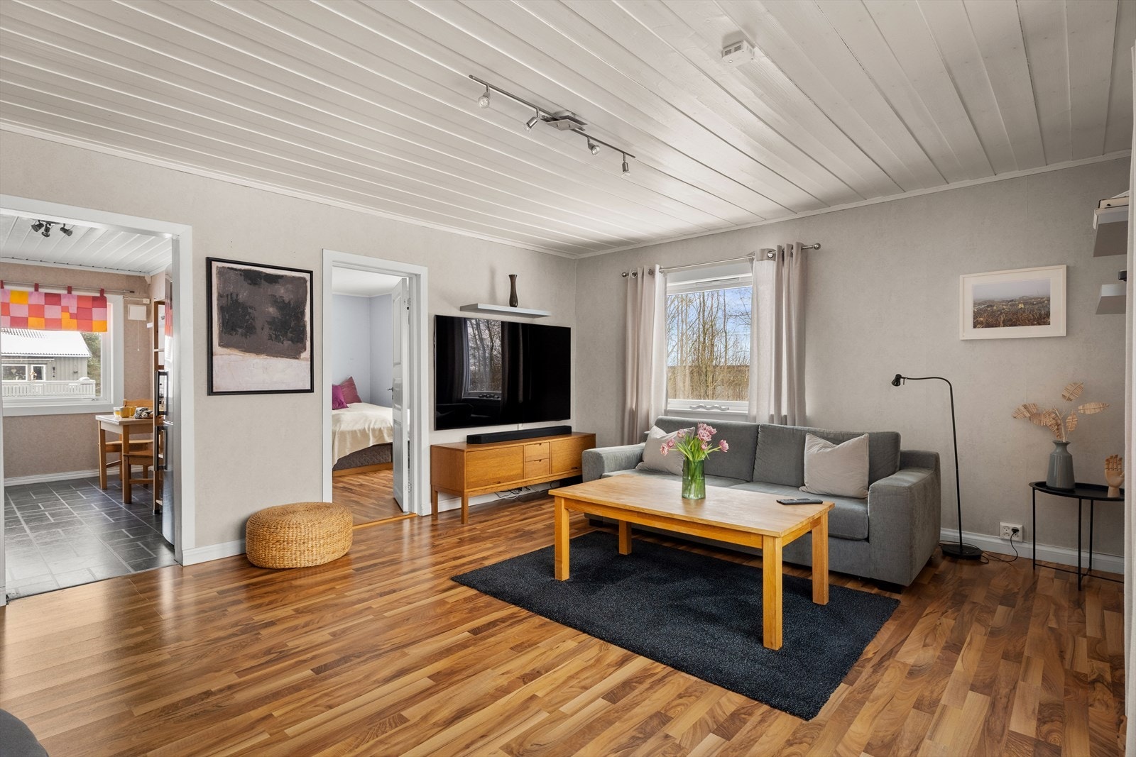 En gjennomgående bruk av laminatgulv skaper en fin flyt mellom rommene. Galleribilde