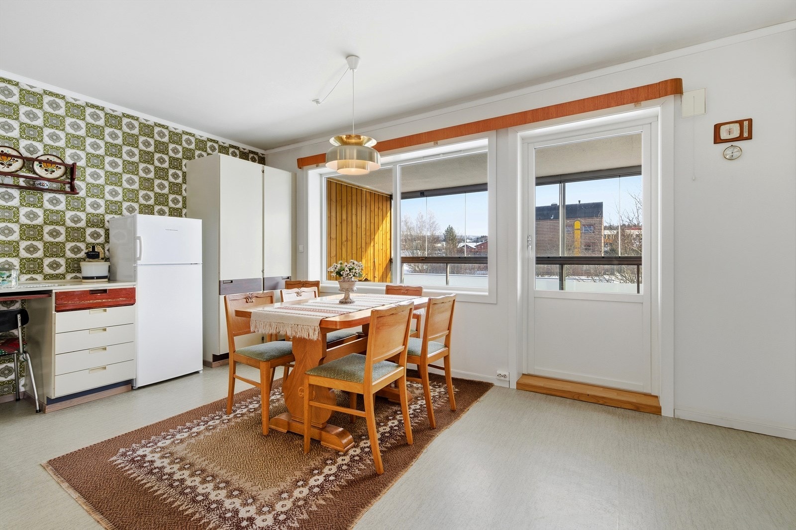 Spiseplassen er praktisk plassert ved kjøkkenet, med direkte utgang til den innglassede balkongen. Galleribilde