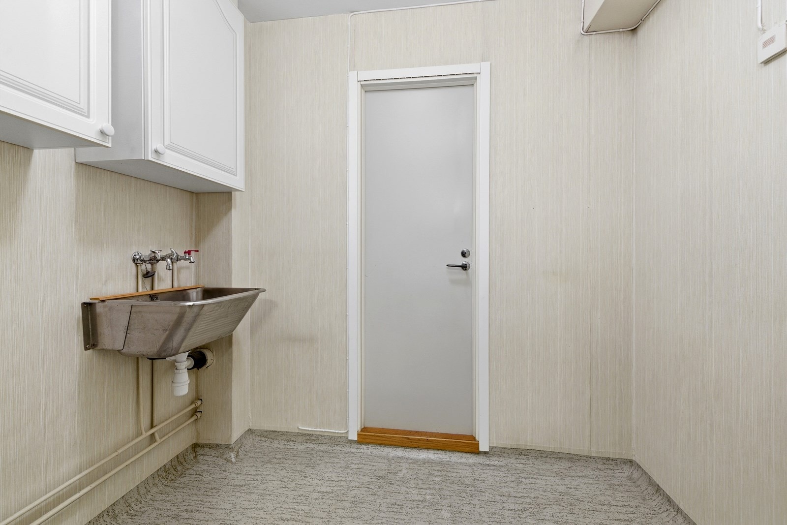 Rommet har en praktisk utslagsvask og vinylbelegg på gulvet med oppkant. Galleribilde