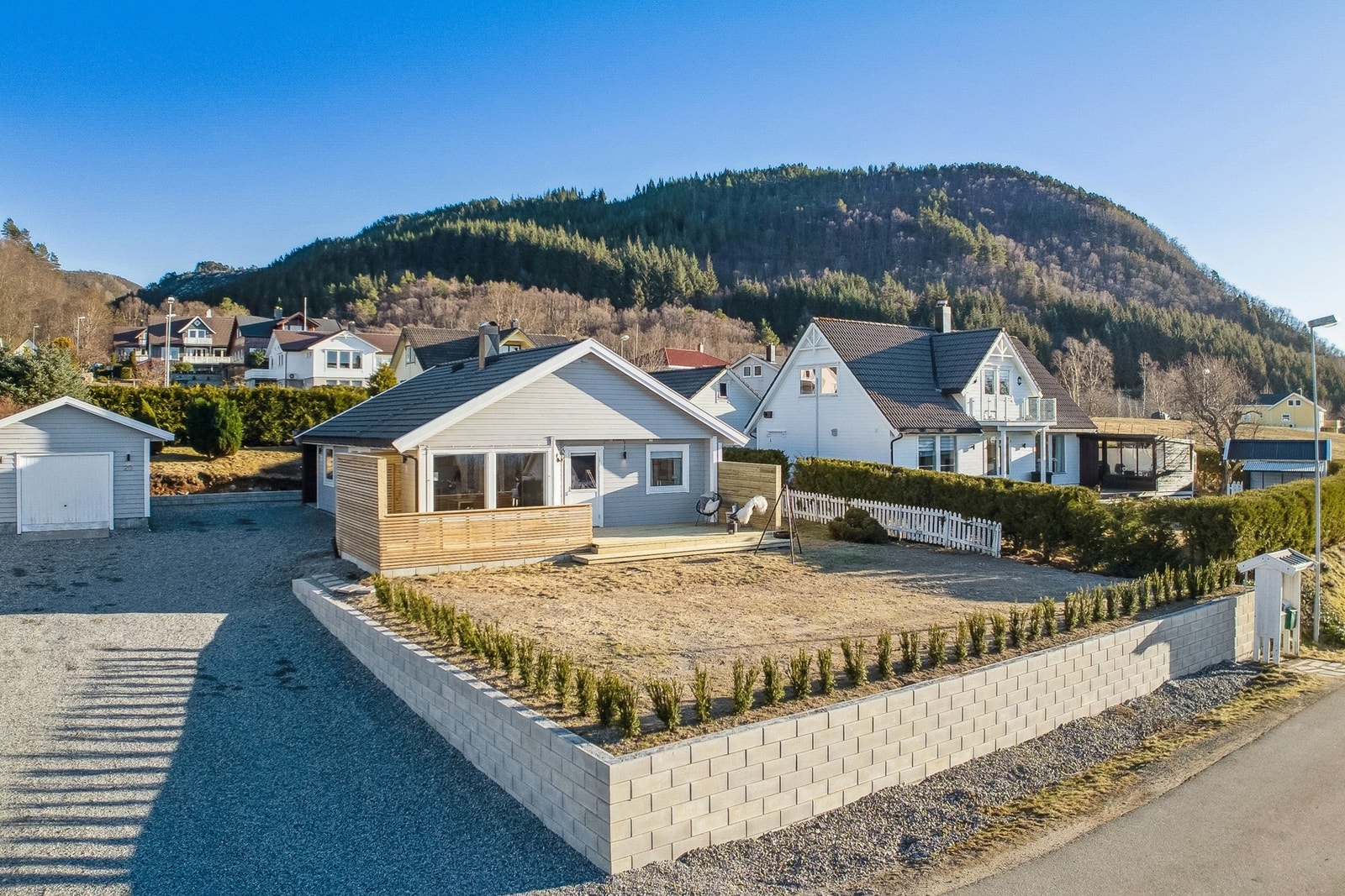 Kjekk planert hage med hekk rundt tomten, det ble sådd gress i fjor. Galleribilde