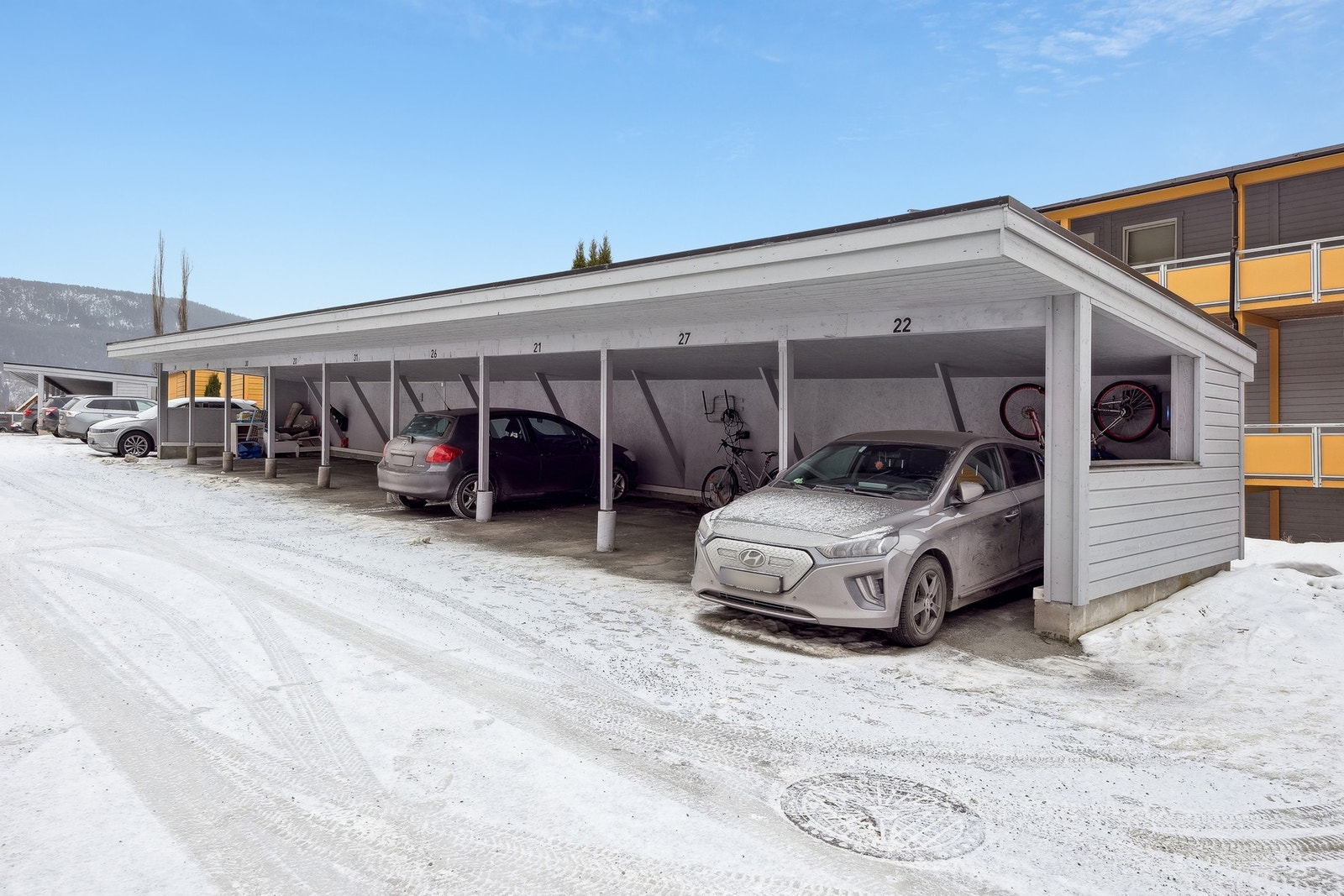 Leiligheten har egen carport med elbil-lader. Det er plass nr. 22 som tilhører leiligheten. Galleribilde