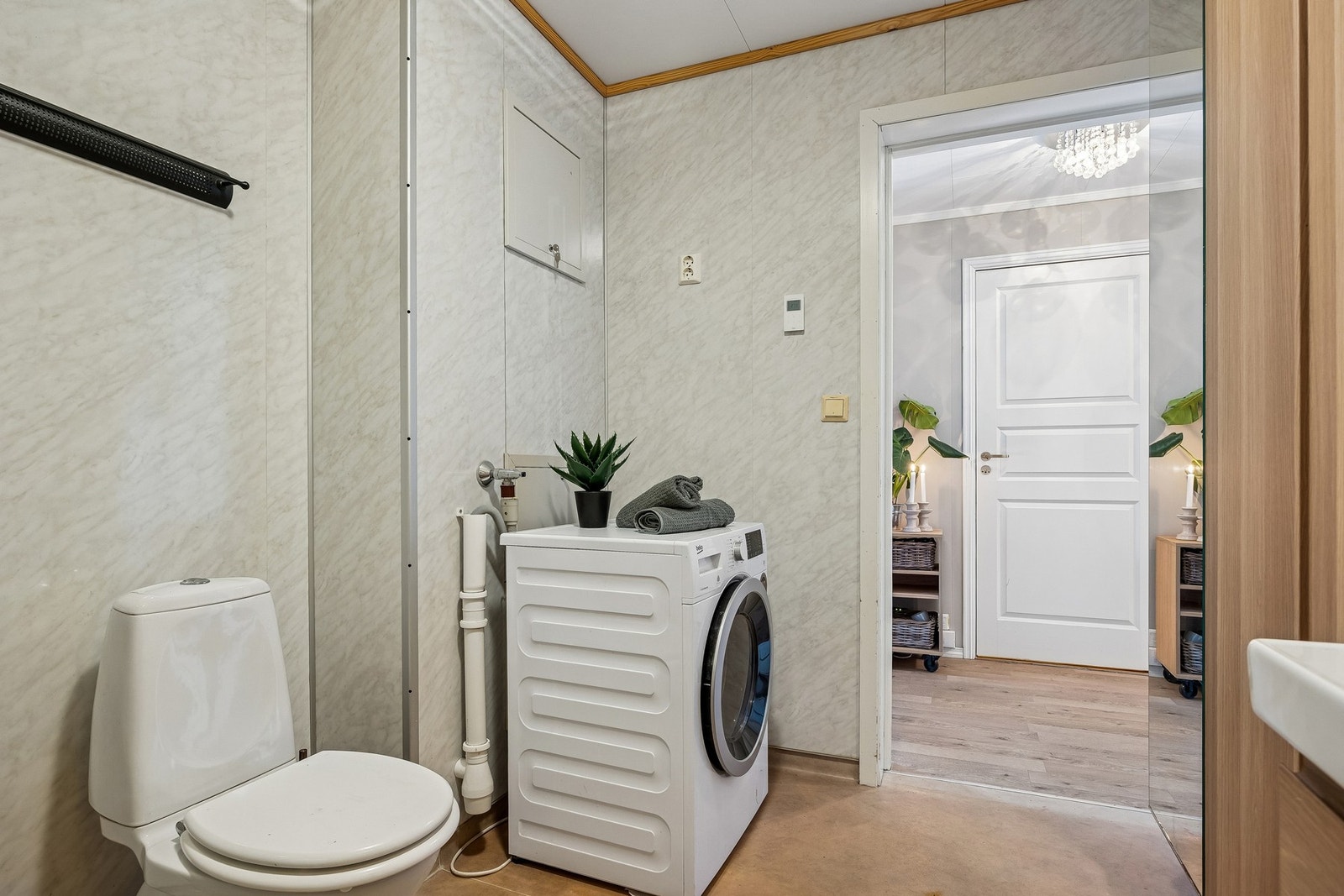 Badet har moderne vegghengt servant med ovenpåliggende servant og armatur, speilskap med overlys, samt praktisk vegghengt høyskap for ekstra oppbevaring. Galleribilde