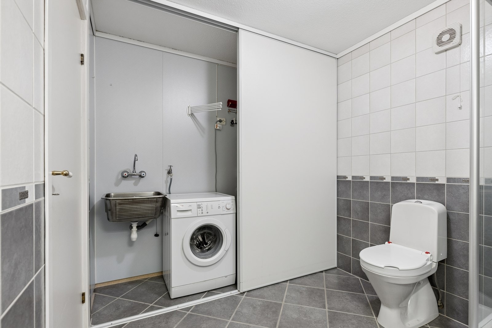 Bad med vaskeromsavdeling som kan skjules bak skyvedører Galleribilde