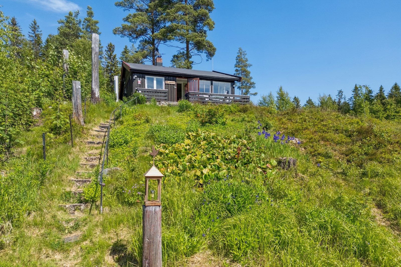 Hytta ligger lunt til i terrenget. En terrengtrapp fører deg opp til hytta Galleribilde