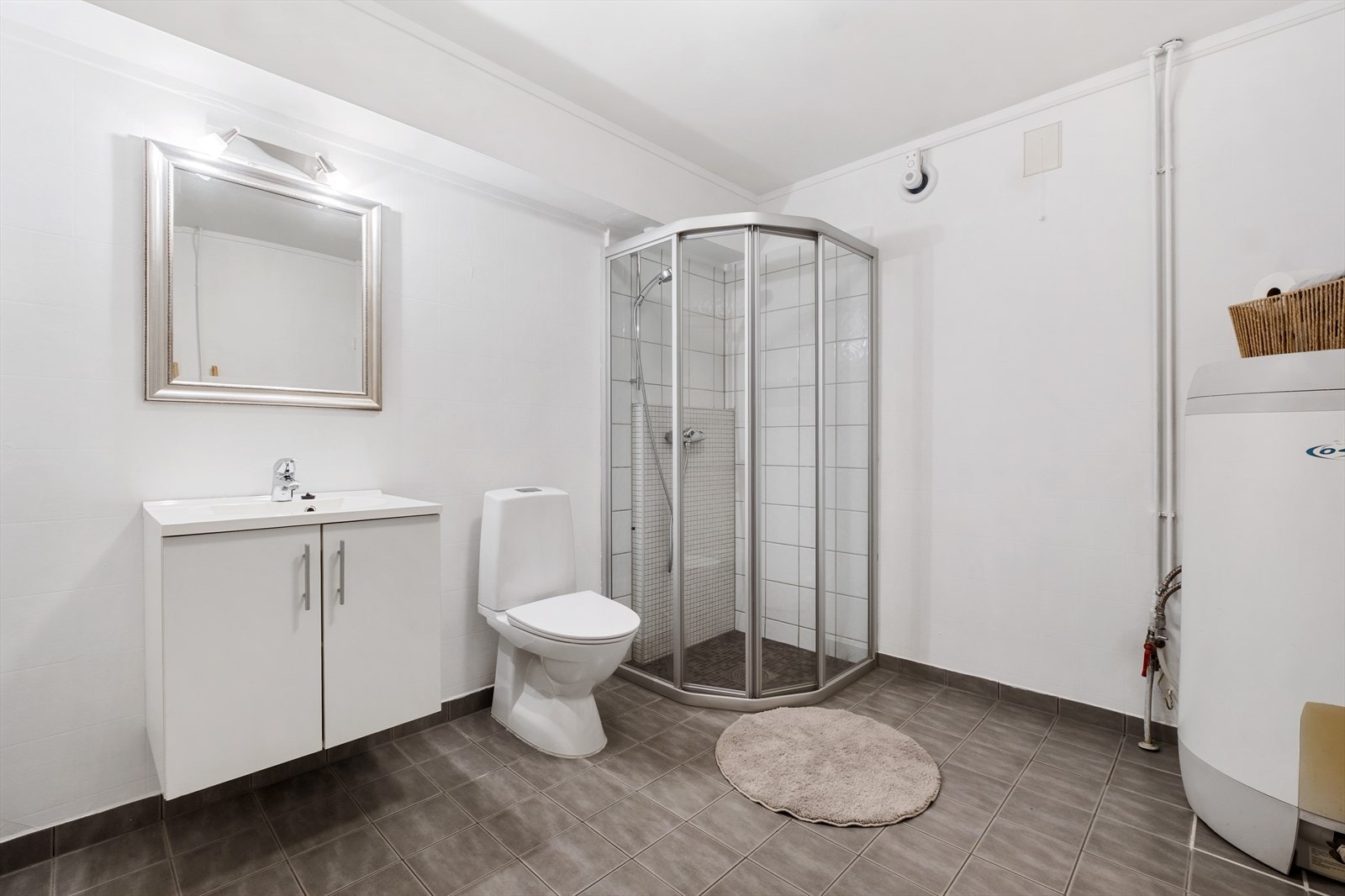 Rommet er utstyrt med servantinnredning, toalett, dusjhjørne med dusjvegger, vv-bereder og opplegg for vaskemaskin. Elektrisk fuktstyrt vifte nylig installert i vegg, i tillegg til ventil med naturlig avtrekk. Galleribilde