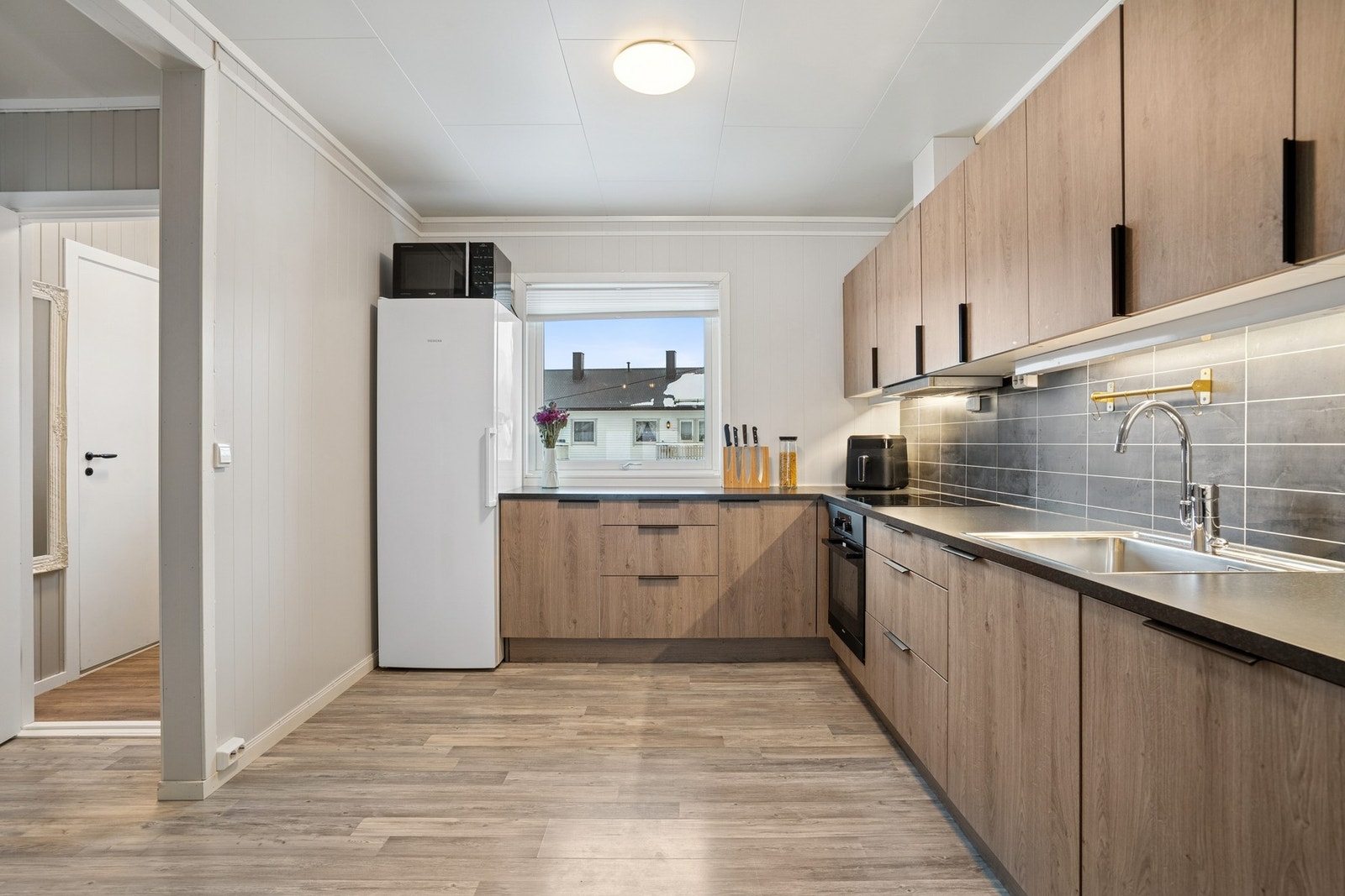 Moderne kjøkken med glatte fronter og laminat benkeplate med nedfelt oppvaskkum. Galleribilde