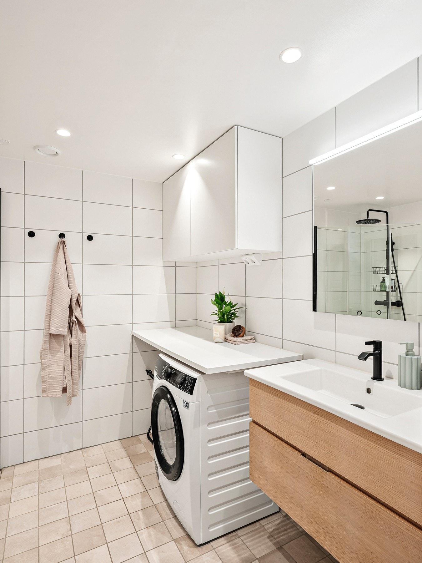 Her finner du innredning med nedfelt servant, toalett, dusjhjørne med glassvegger og opplegg for vaskemaskin. Galleribilde