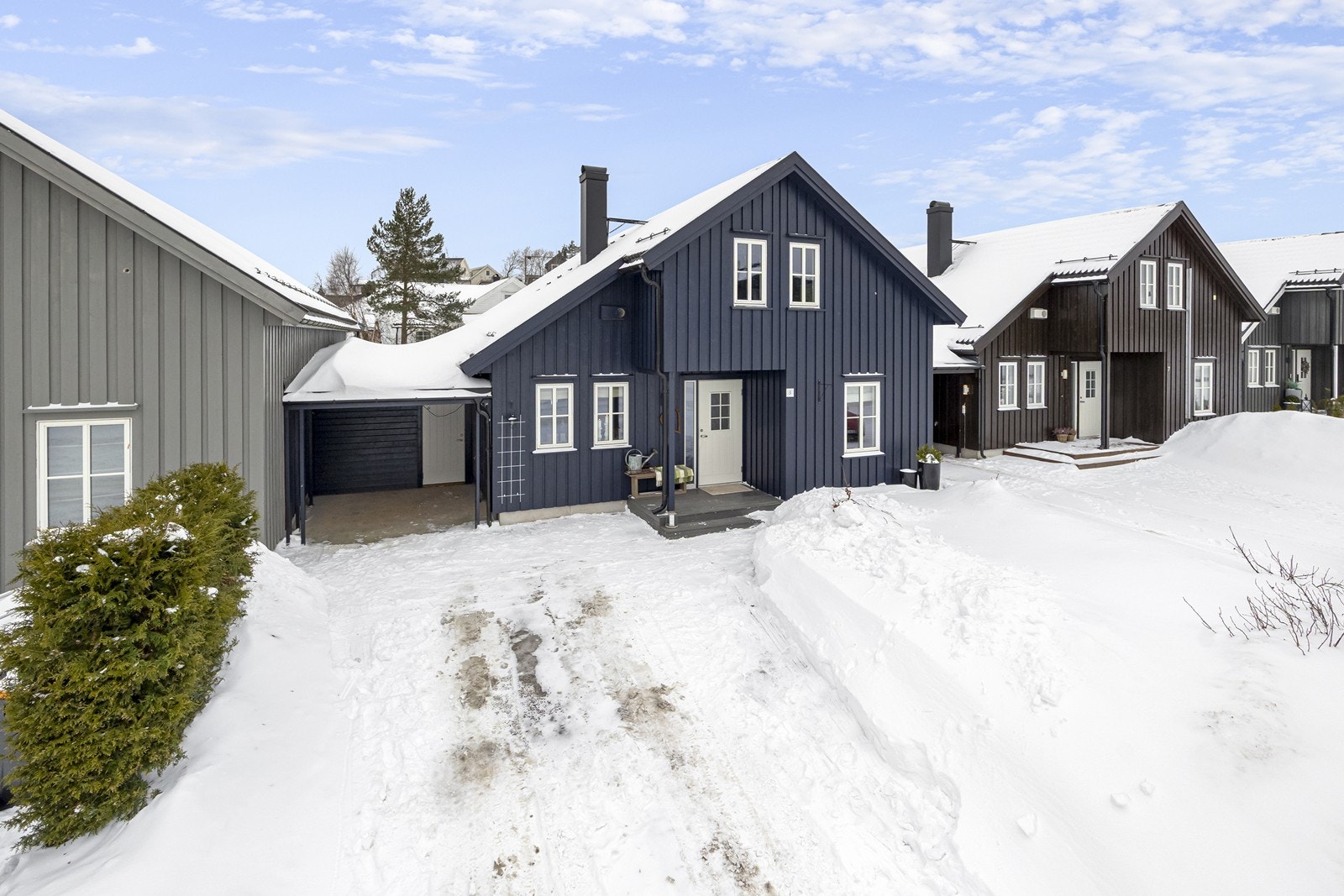 Enebolig i kjede med carport og god plass til parkering. Innenfor carport er det romslig bod, deretter hagestue og så kommer man videre til terrasse. I tillegg er det godp lass til parkering på egen tomt. Foran huset er det plan, hekk og diverse bærbusker Galleribilde