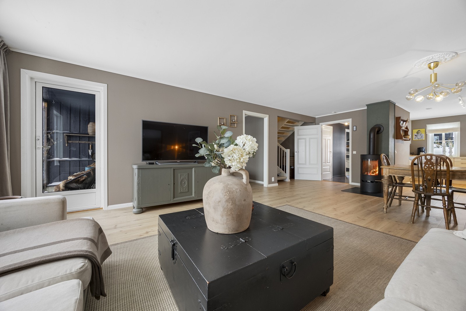 Boligen er malt i moderne og innbydende farger. Peisovn i stue. Galleribilde