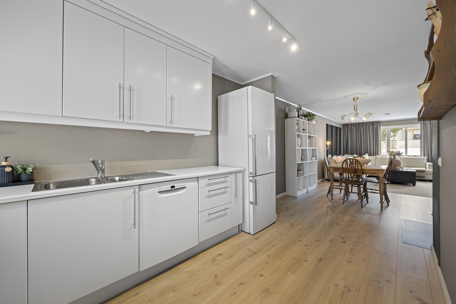 Pent, hvitt kjøkken med hvitevarer. Galleribilde