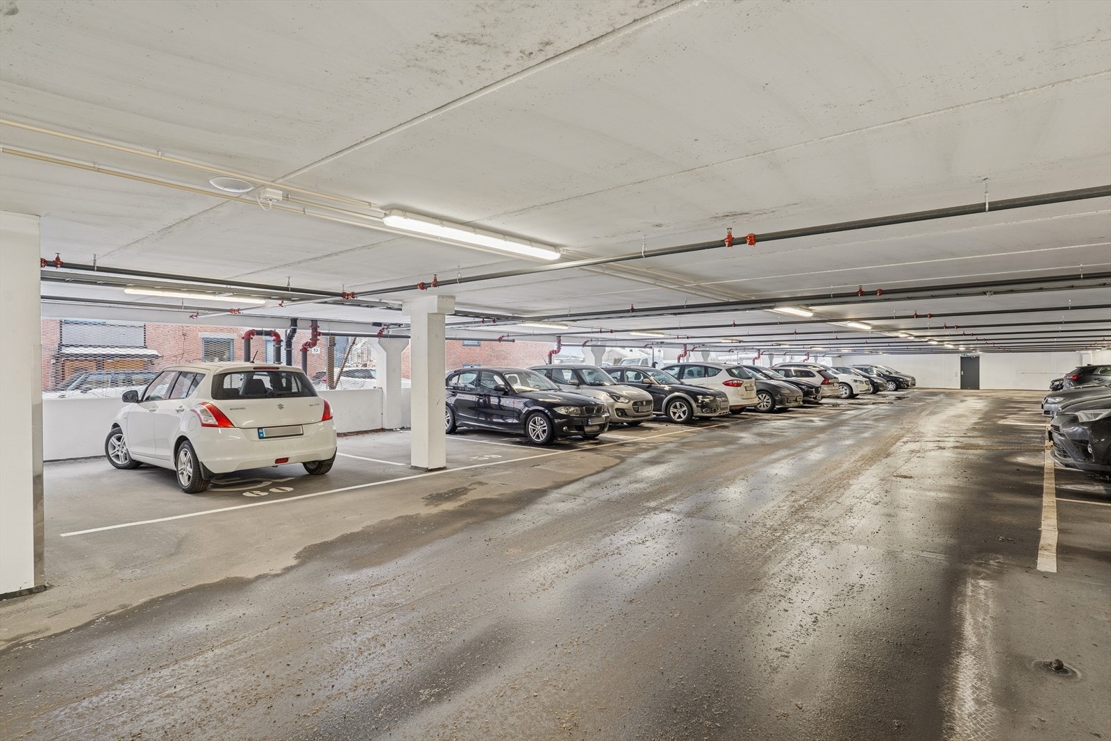 Nyere parkeringsanlegg fra 2022 der leiligheten disponerer en merket parkeringsplass Galleribilde