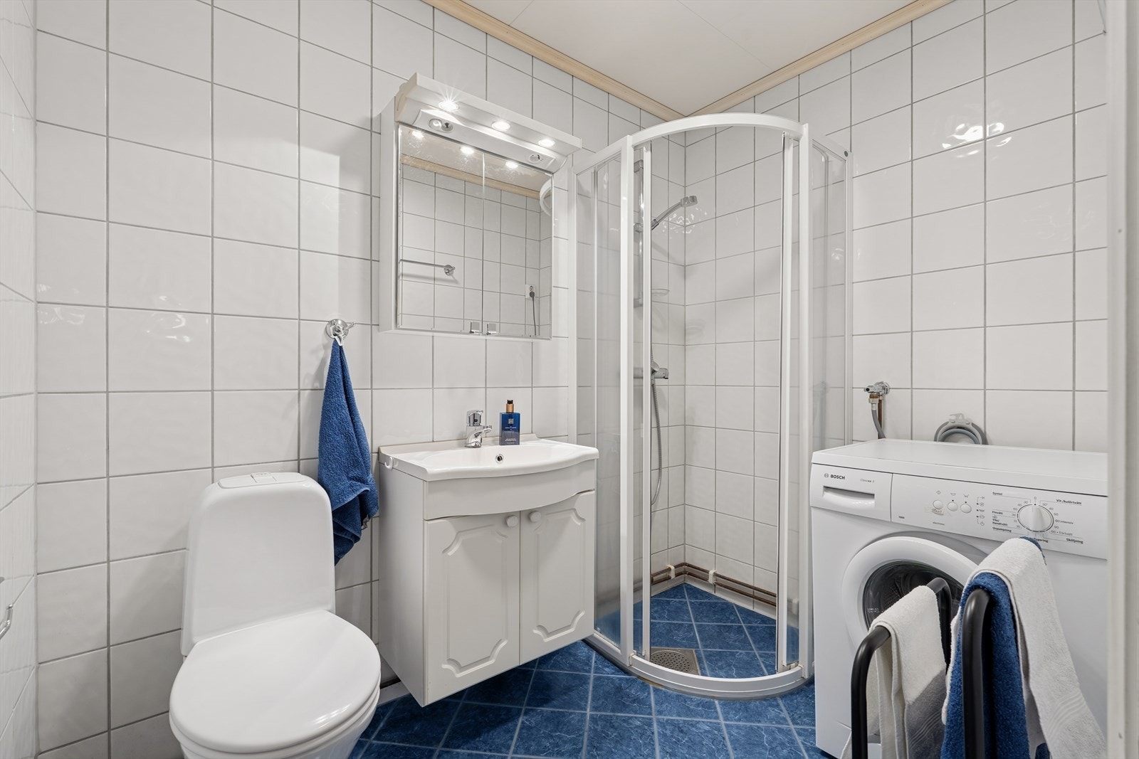 Flislagt bad med gulvvarme og opplegg for vaskemaskin Galleribilde