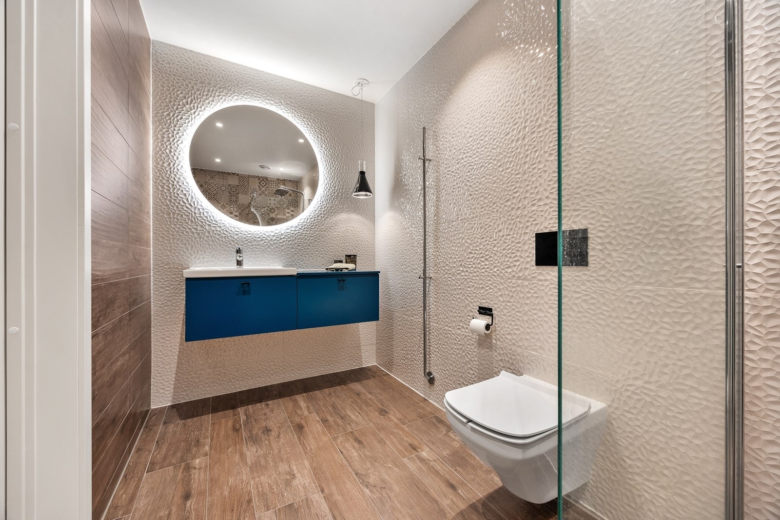 Baderomsinnredning med god oppbevaringsplass og et stort speil med integrert belysning. Galleribilde