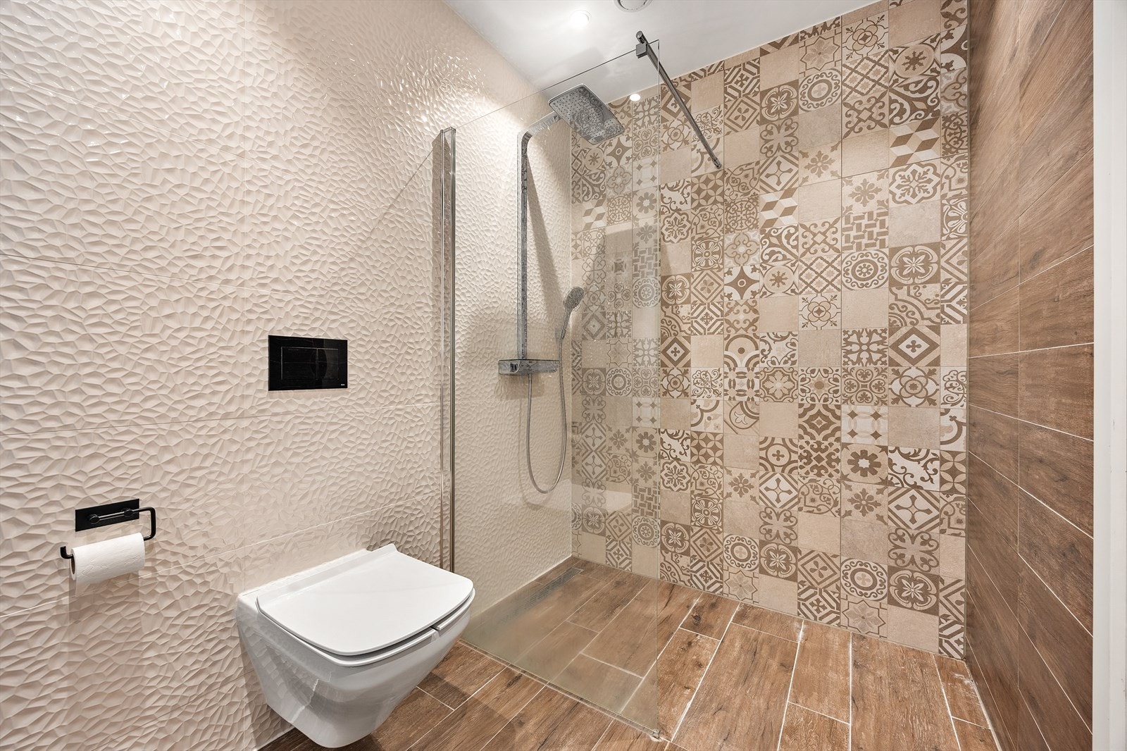 Dusjnisje med regnfallsdusj og glassvegg, samt vegghengt toalett. Galleribilde