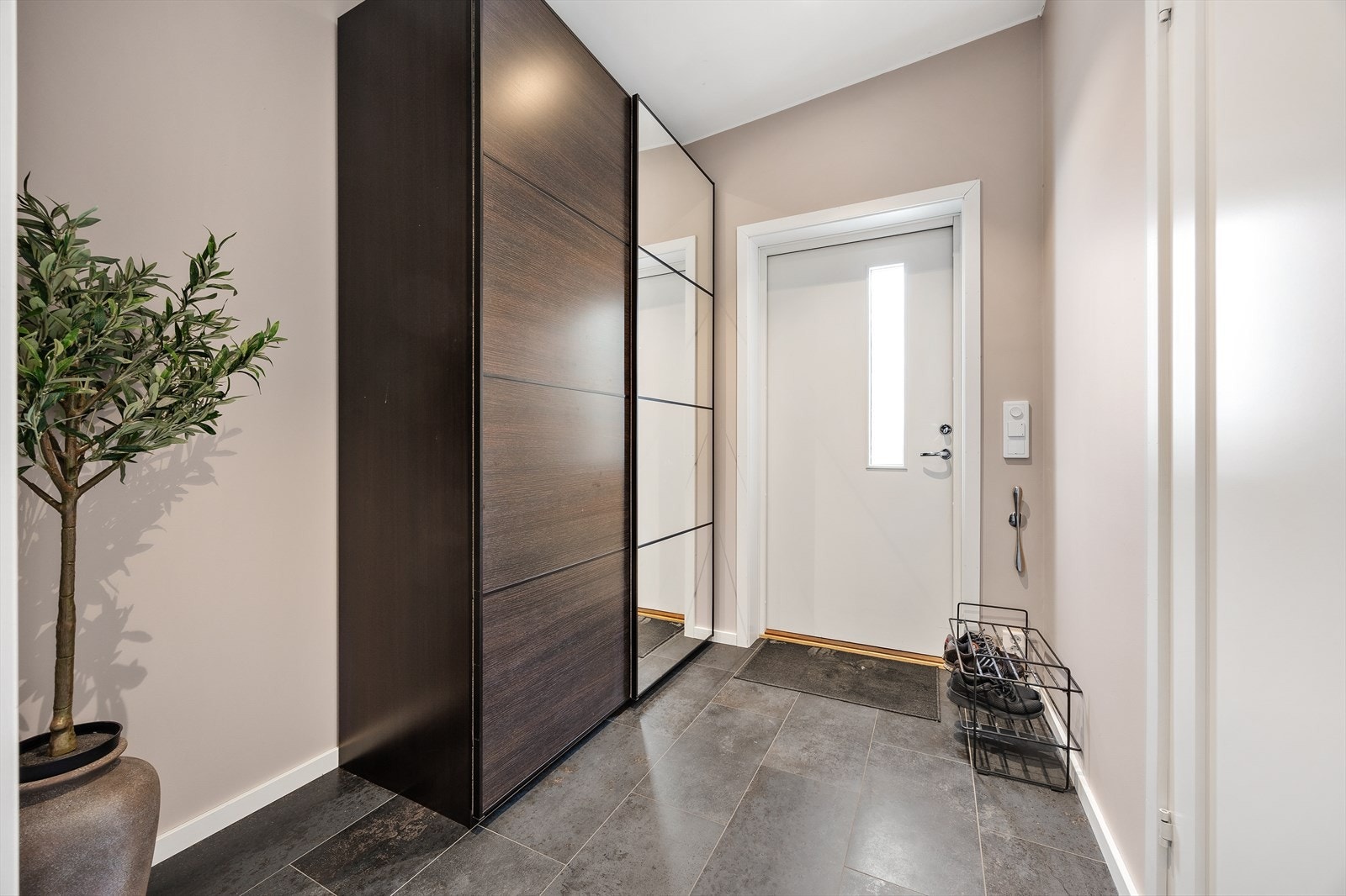 Velkommen inn i en lys entré med flislagt gulv og god plass til garderobeløsning. Galleribilde